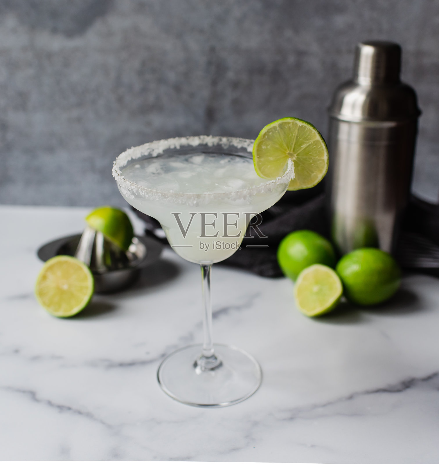 近距离的玛格丽塔鸡尾酒与酸橙和摇壶大理石柜台照片摄影图片