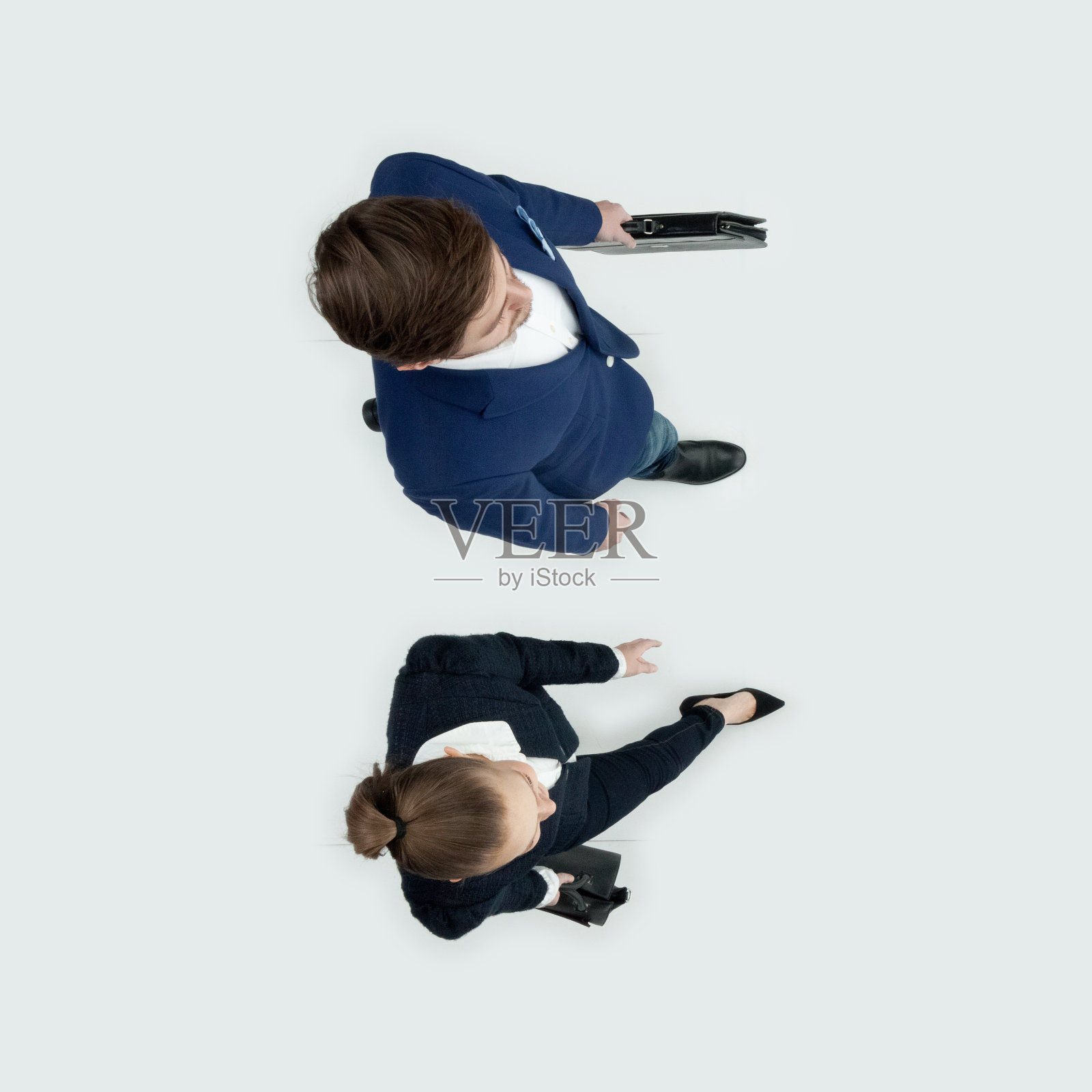 年轻的白人女性潮人走在白色的背景，穿着商务服装，拿着公文包照片摄影图片