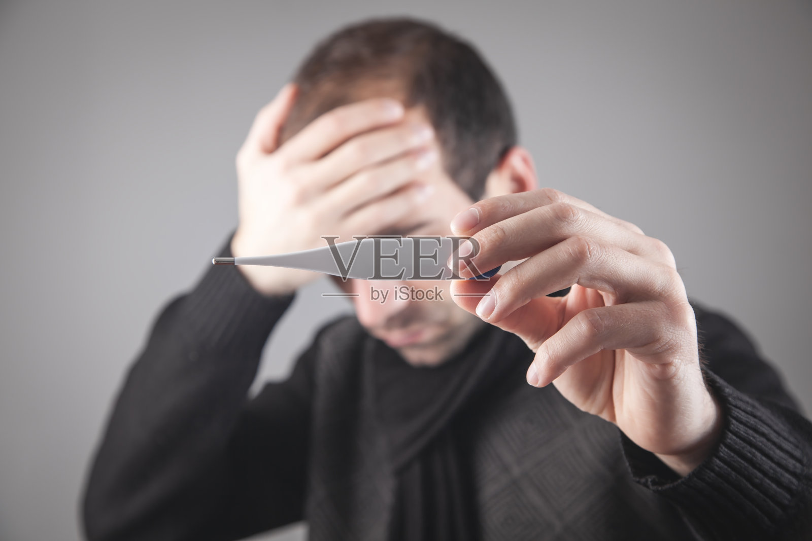 一个白人在家里测体温。照片摄影图片