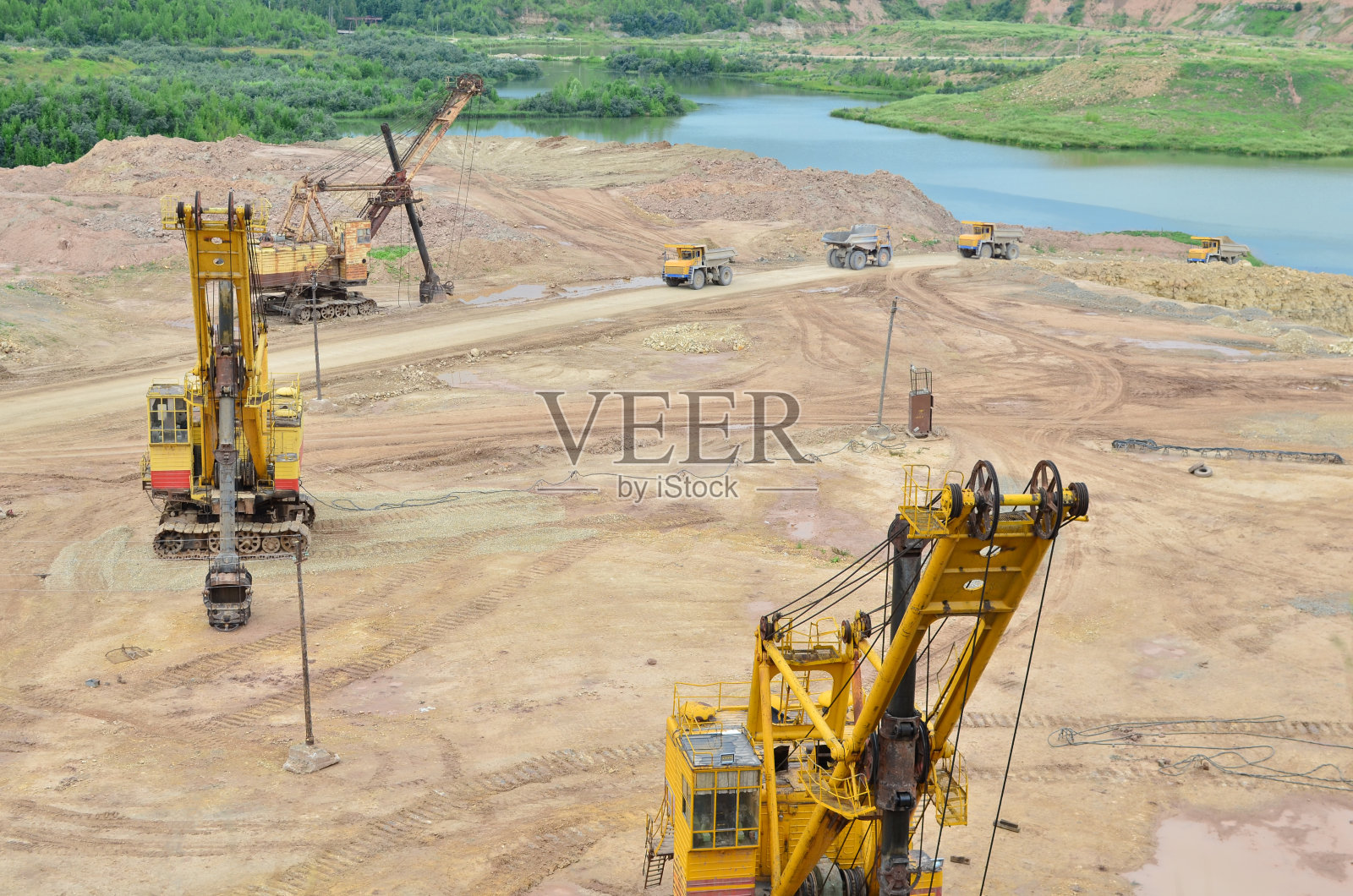 巨大的挖掘机与电铲在采石场工作。大型自卸卡车在石灰石露天开采中运输矿物。白俄罗斯，维捷布斯克地区最大的白云岩露天矿照片摄影图片