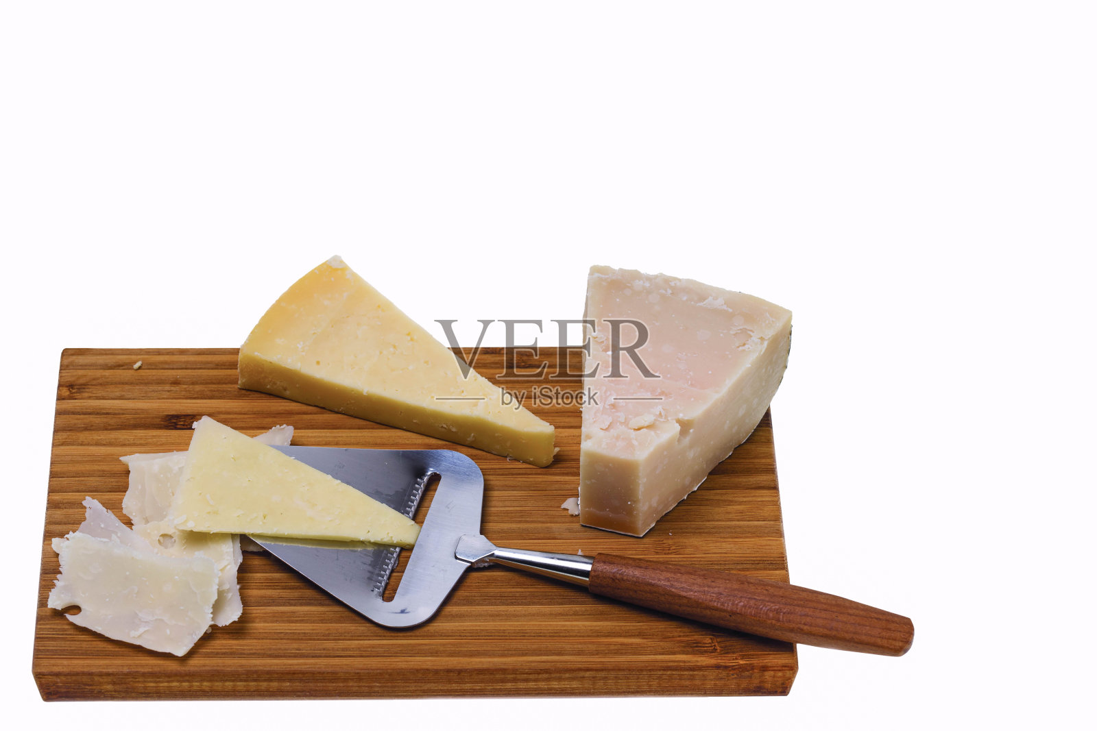 用奶酪刀将不同种类的奶酪隔放在木板上。健康食品的概念。照片摄影图片