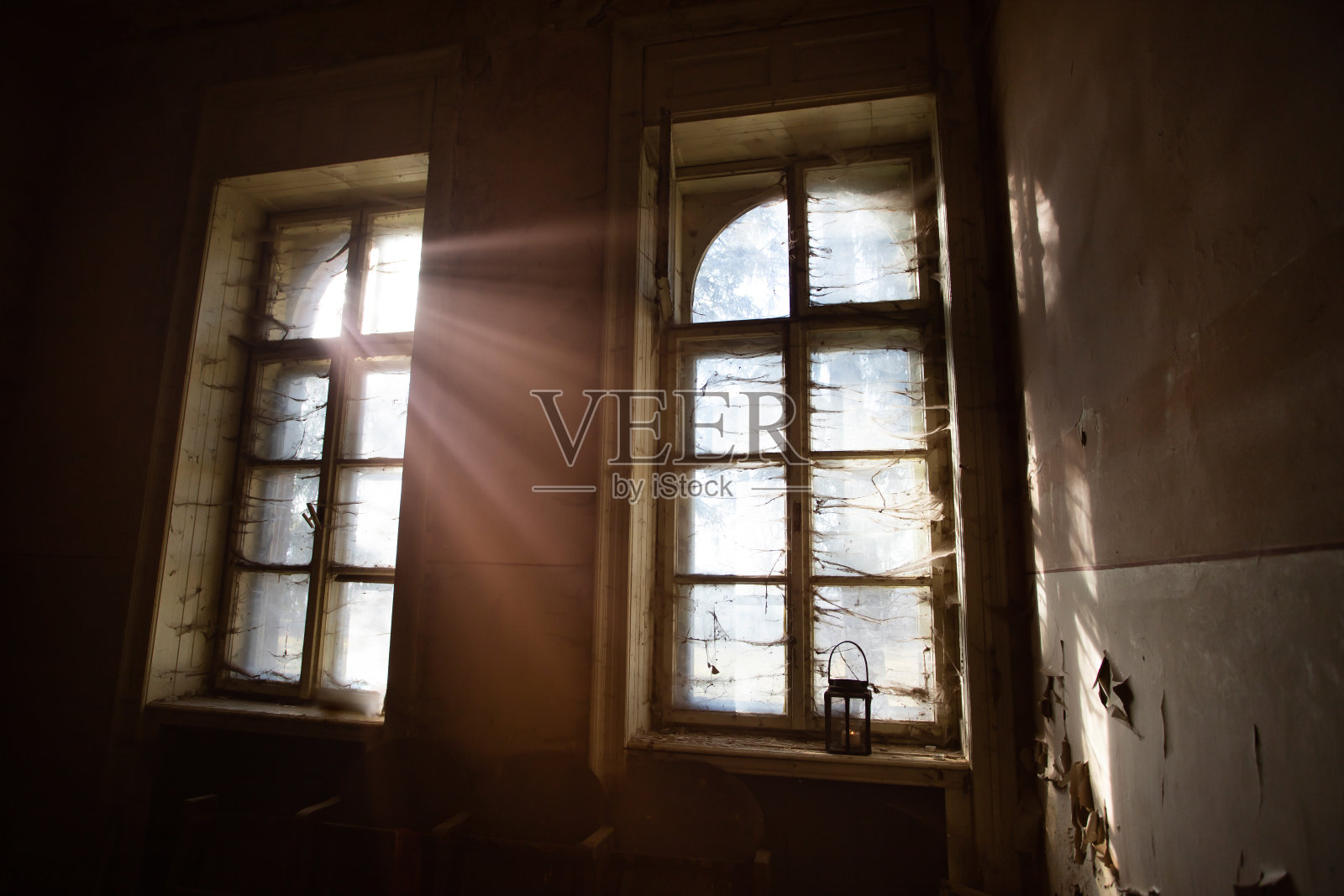 诡异的窗户上挂着灯笼和蜘蛛网。照片摄影图片