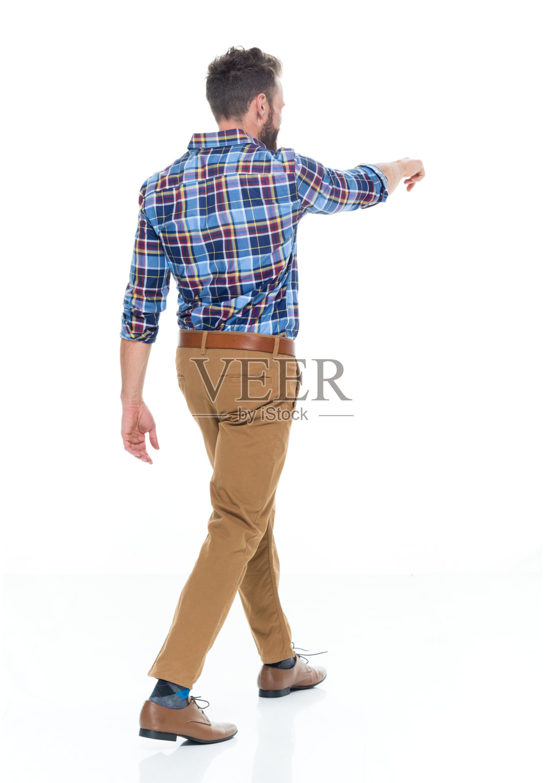 白人男性穿着卡其布裤子走在白色背景前照片摄影图片