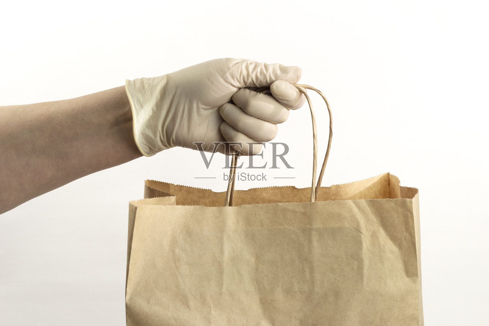 手在白色乳胶手套握纸袋在白色背景照片摄影图片