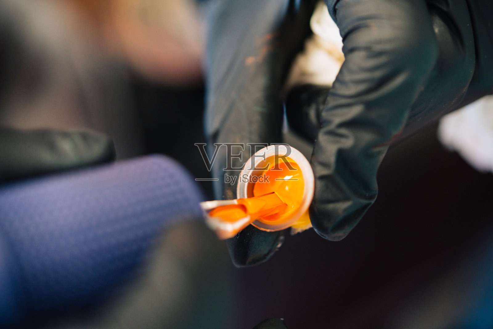 纹身女往纹身机里装墨水。照片摄影图片