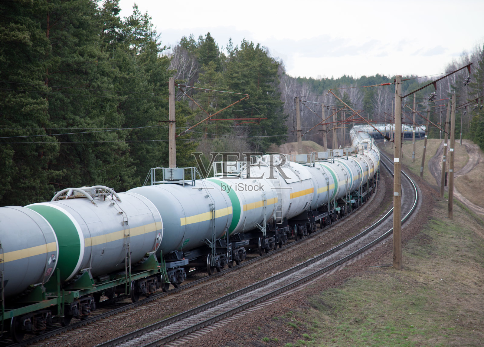 铁路上装有油罐车的货运列车。火车运载石油和乙醇。铁路物流易爆货物。运输甲醇、原油和天然气。石化油罐汽车照片摄影图片