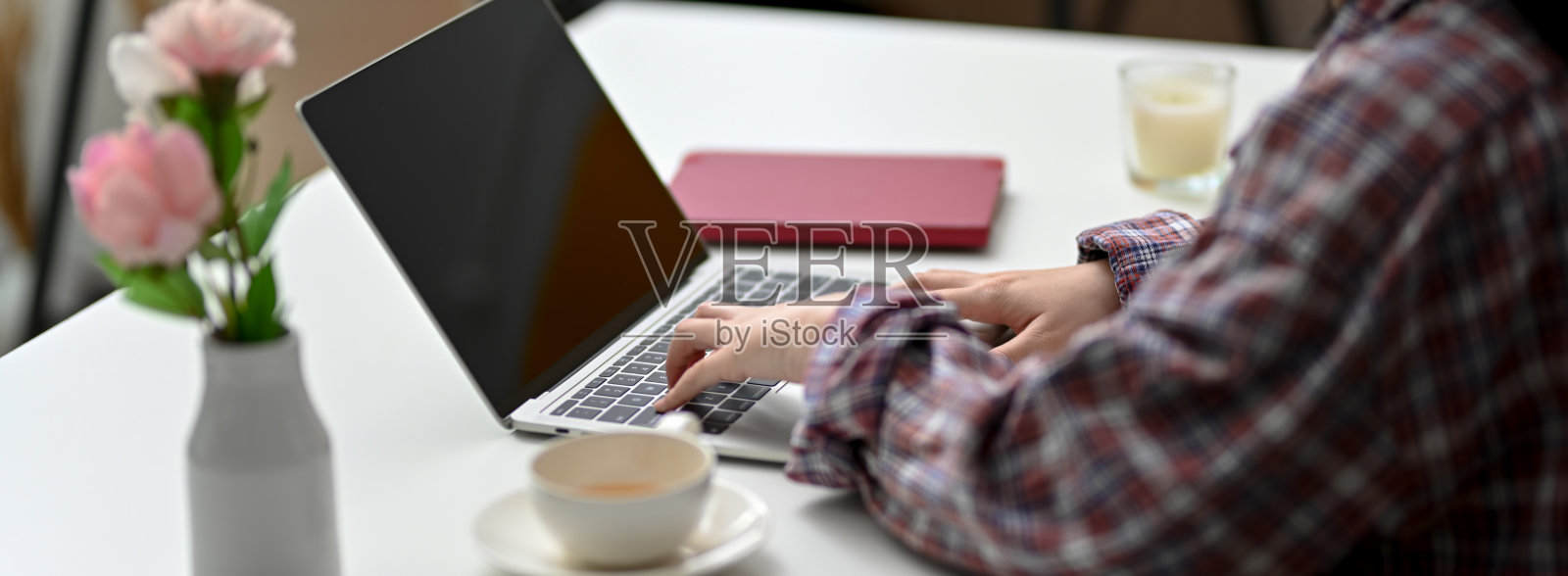 侧视图的女性自由职业者在她的项目与笔记本电脑，用品和装饰照片摄影图片