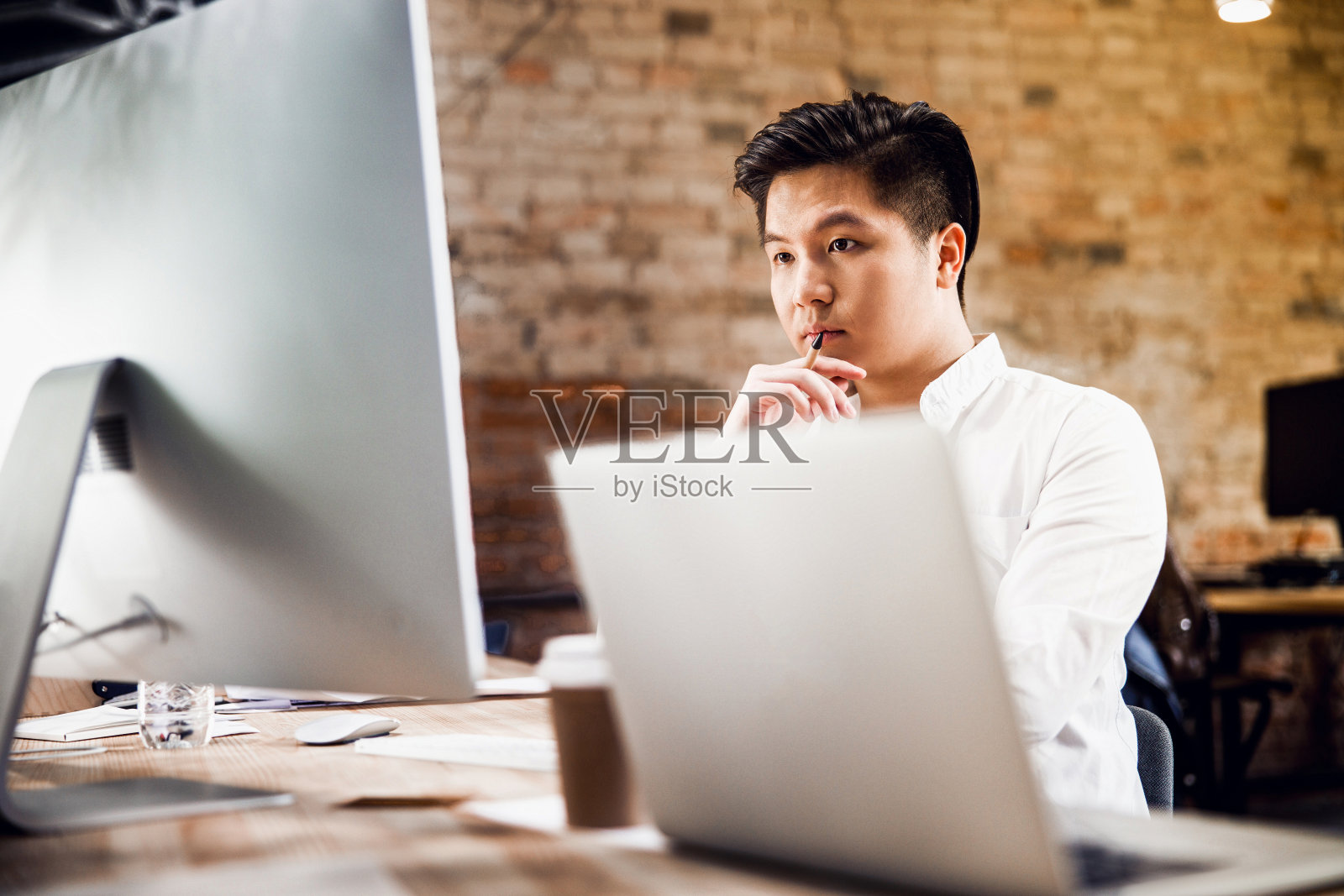 一个严肃的年轻人用现代电脑工作照片摄影图片