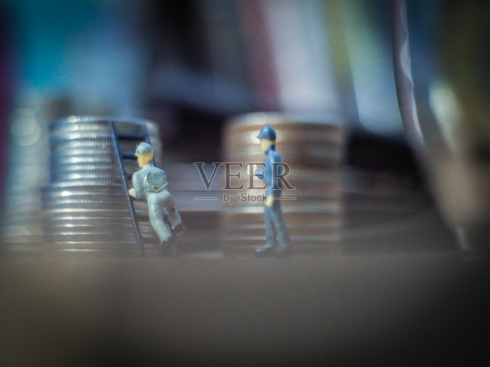 站在硬币上的小人。研究硬币照片摄影图片