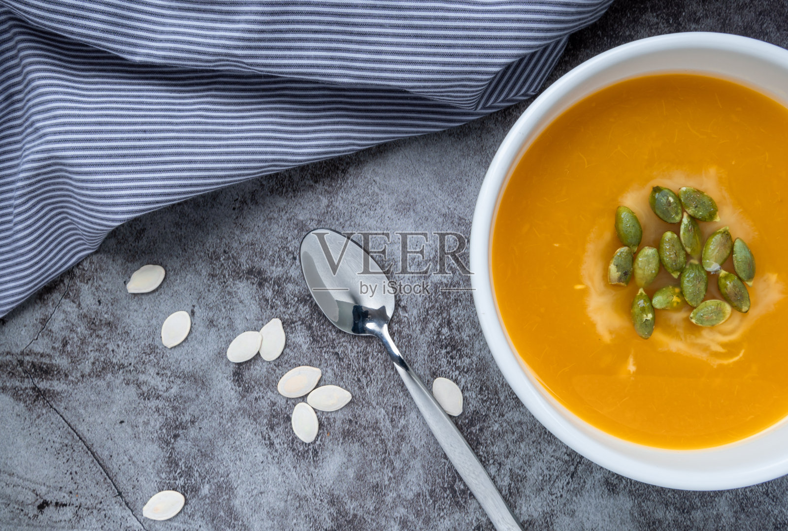 自制南瓜汤在碗里与南瓜子，俯视图，复制空间。季节秋天的食物。素食照片摄影图片