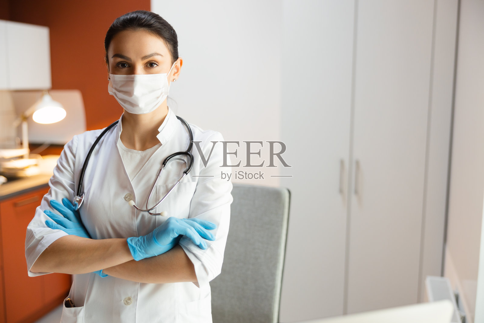 年轻的儿科医生带着听诊器在相机前摆姿势照片摄影图片