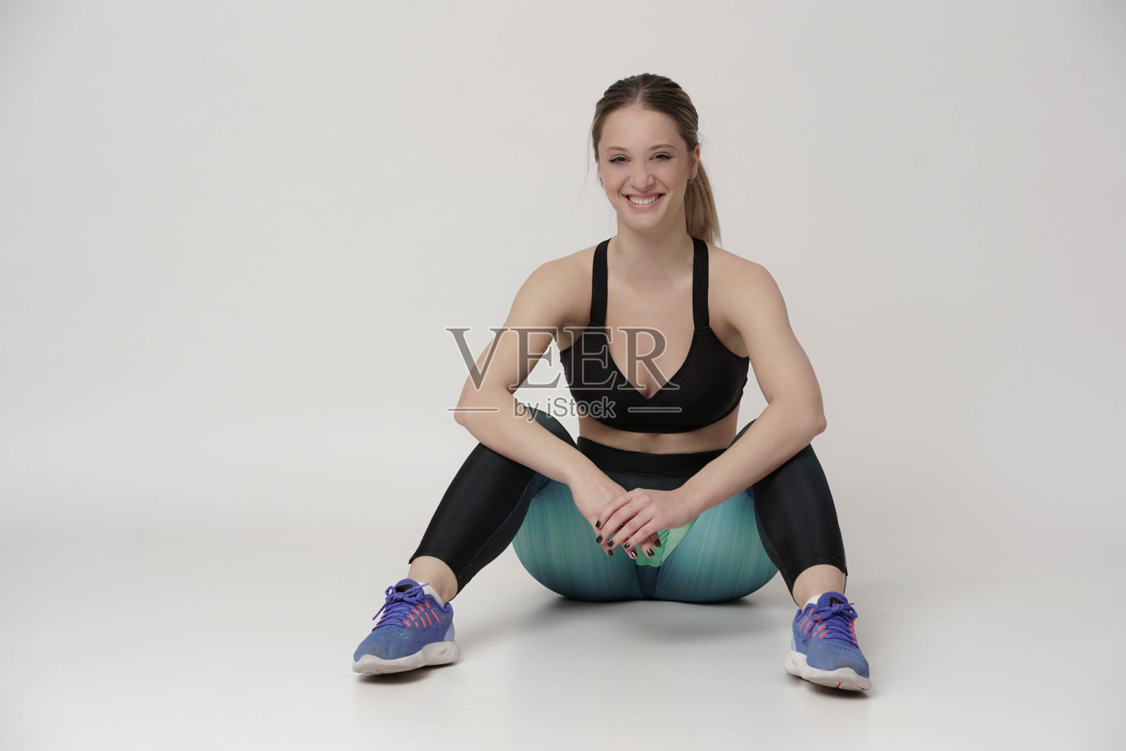 欢快的女人用哑铃在粉红色的背景下锻炼照片摄影图片