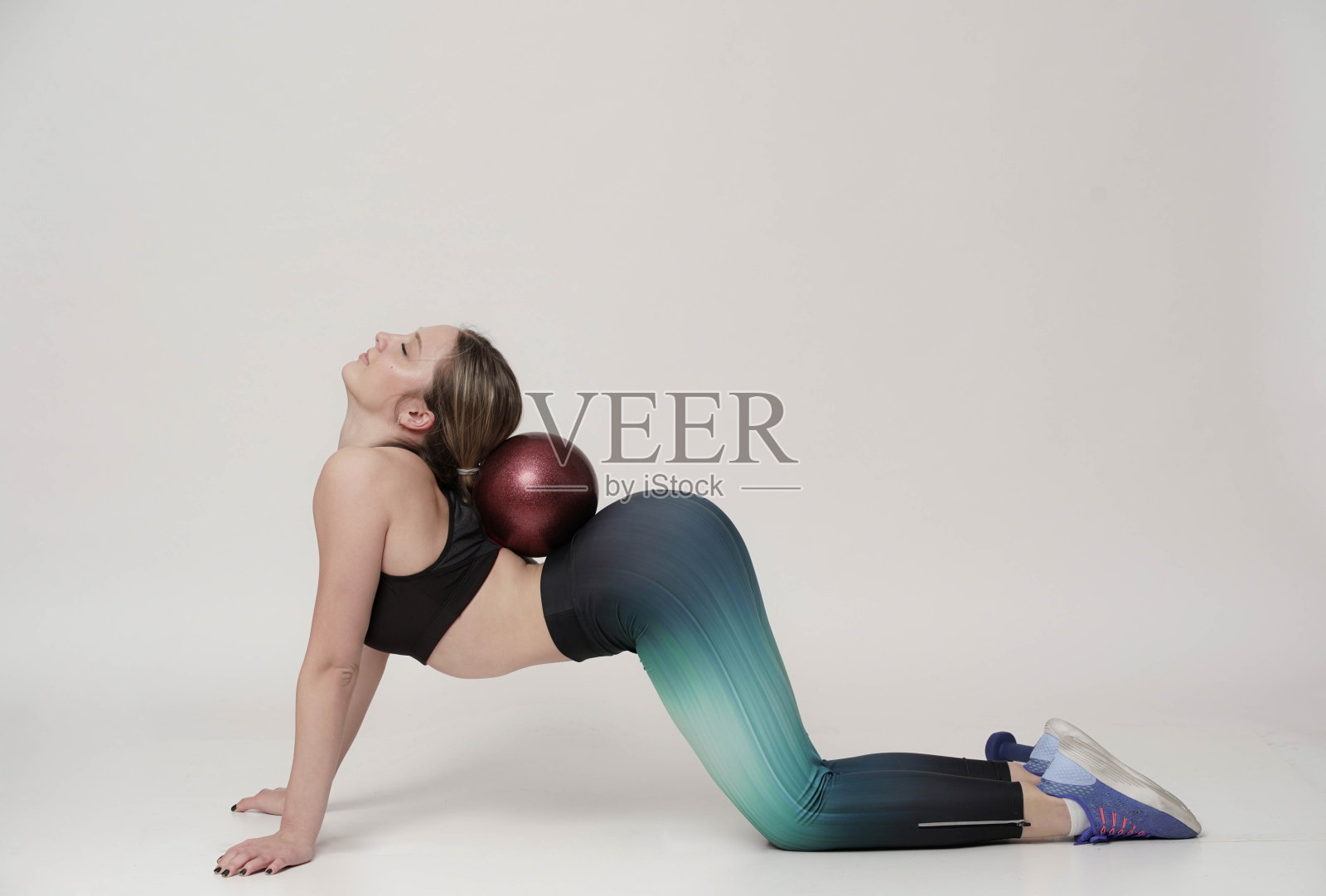 欢快的女人用哑铃在粉红色的背景下锻炼照片摄影图片
