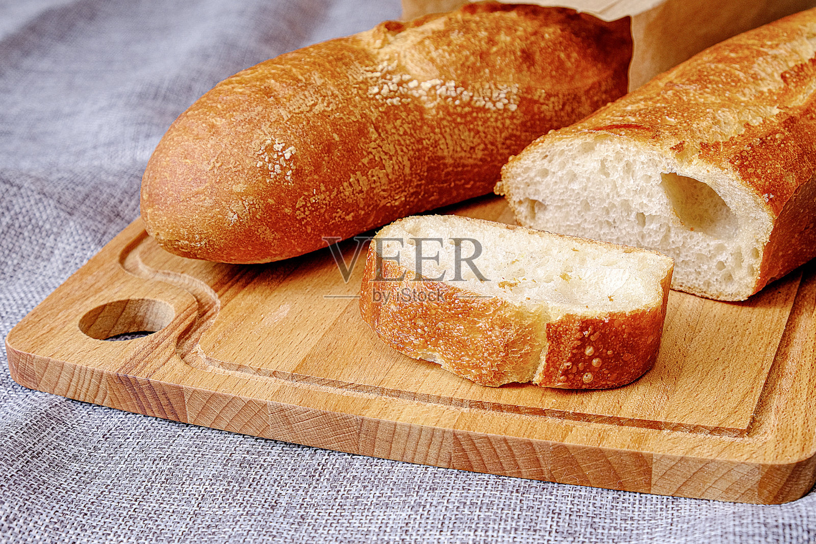 模糊的焦点，艺术模糊。软计划。新鲜温暖的法棍面包，外皮酥脆。切片吃早餐。早上吃三明治。照片摄影图片