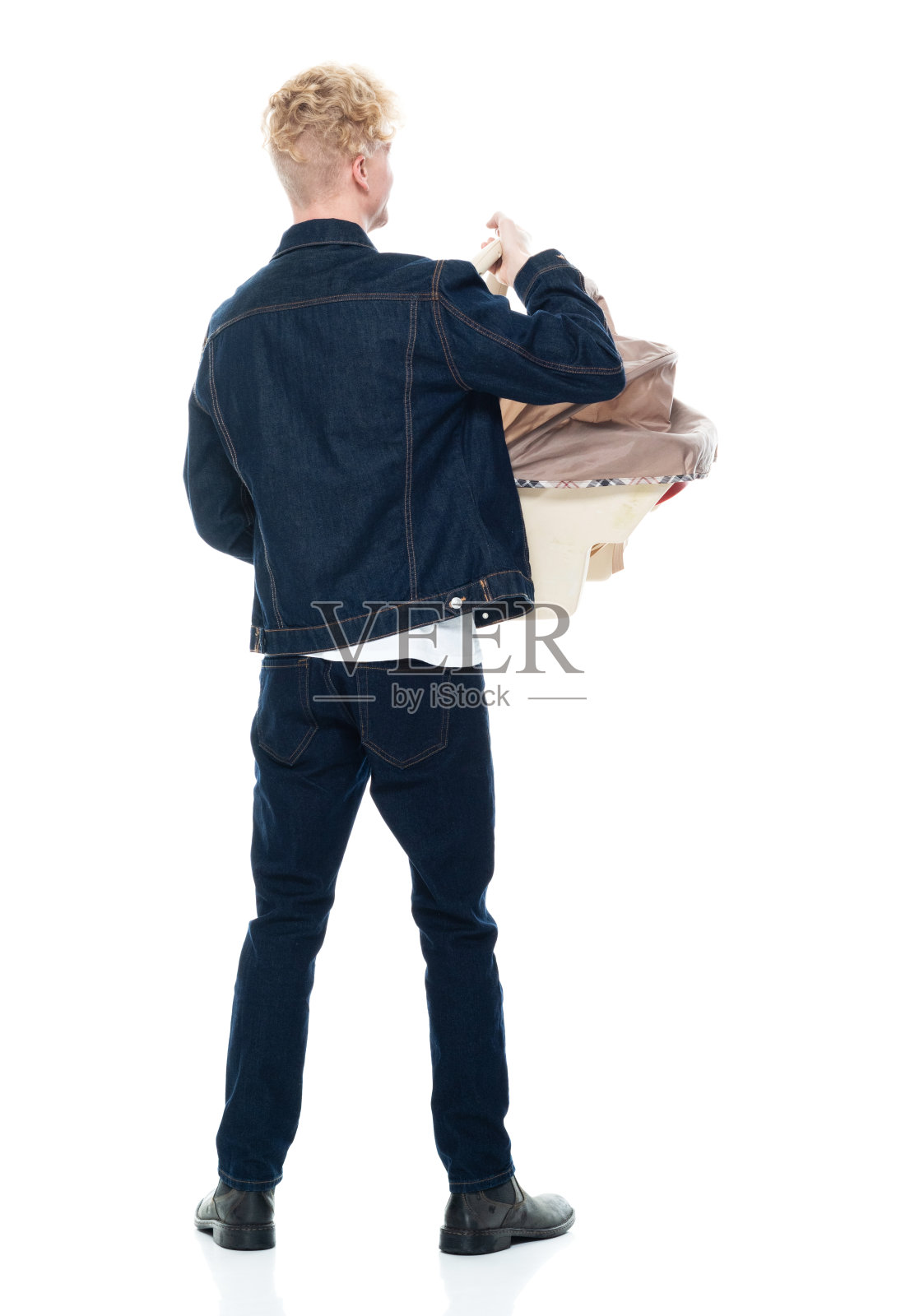 白人婴儿-人类年龄站在白色背景穿着牛仔裤和持有汽车安全座椅照片摄影图片