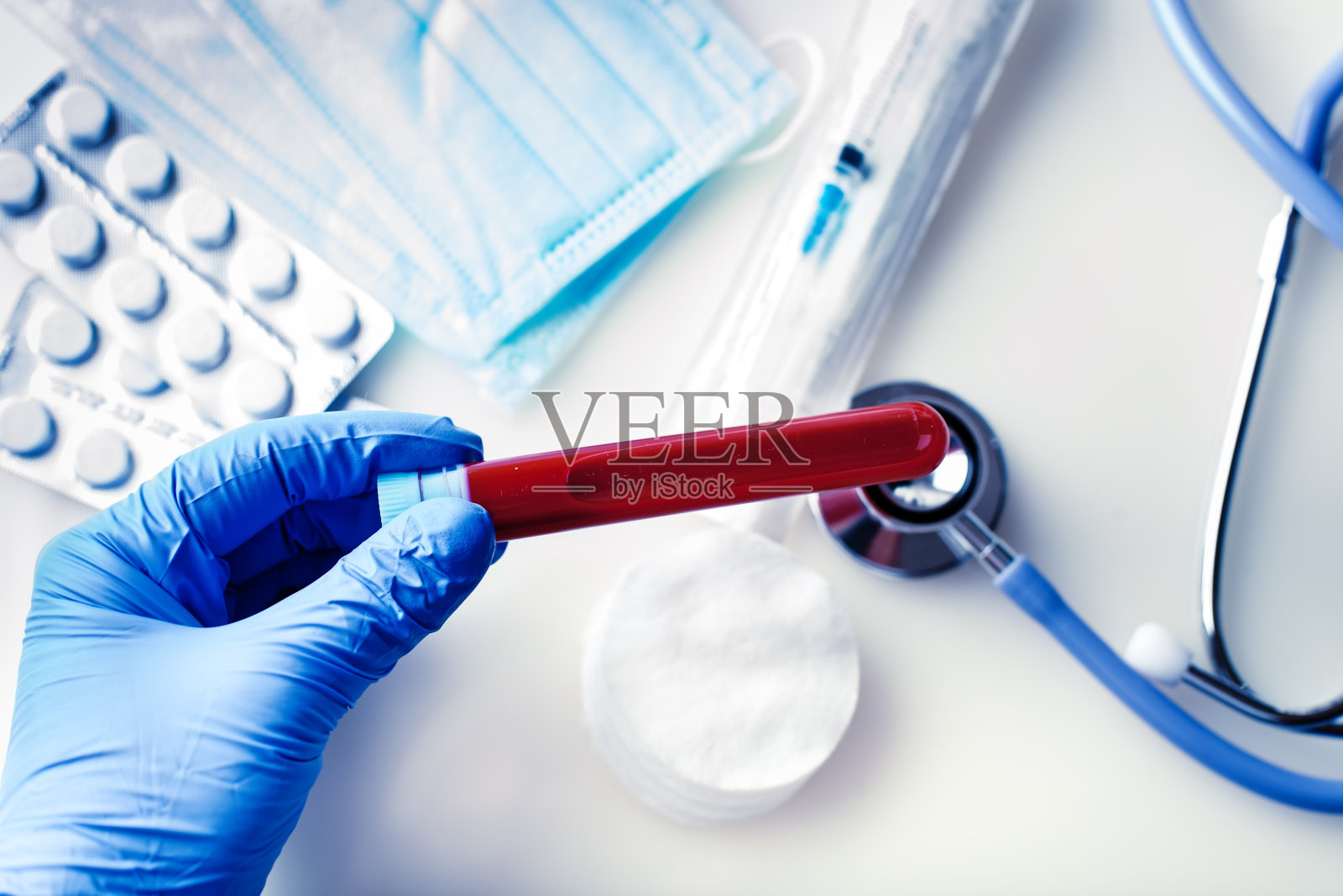 冠状病毒的流行。医生的手拿着一瓶血样。照片摄影图片