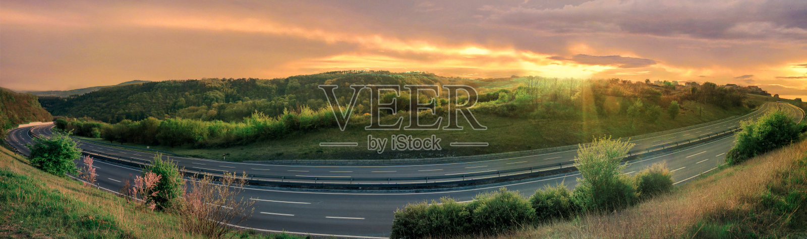 在美丽的日落下，空旷的公路上坡。照片摄影图片