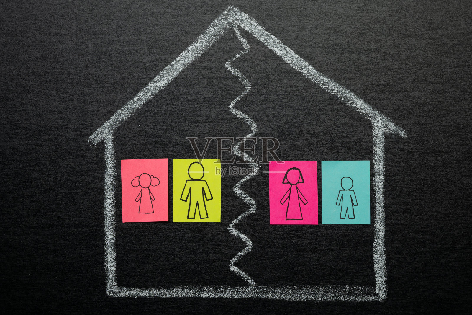 在黑板上画着房子里的一对夫妇，丈夫和妻子，划掉了线。家庭关系的概念，家庭问题。照片摄影图片