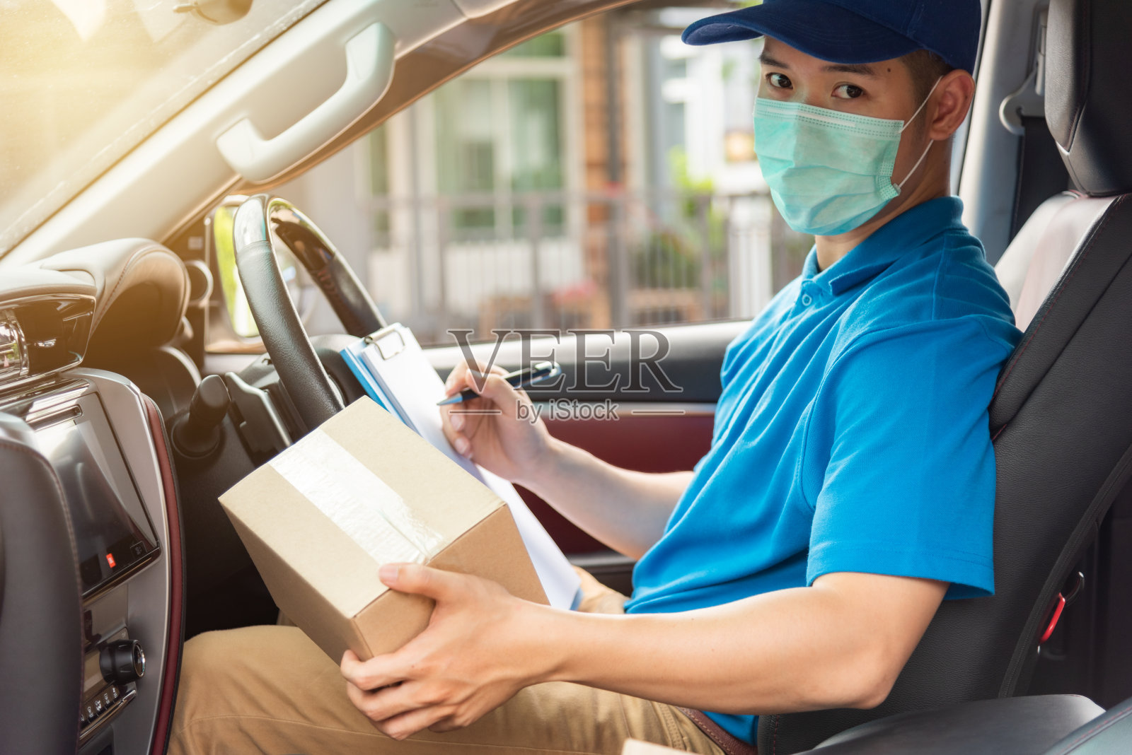 快递员正在检查要送到车上的包裹。照片摄影图片