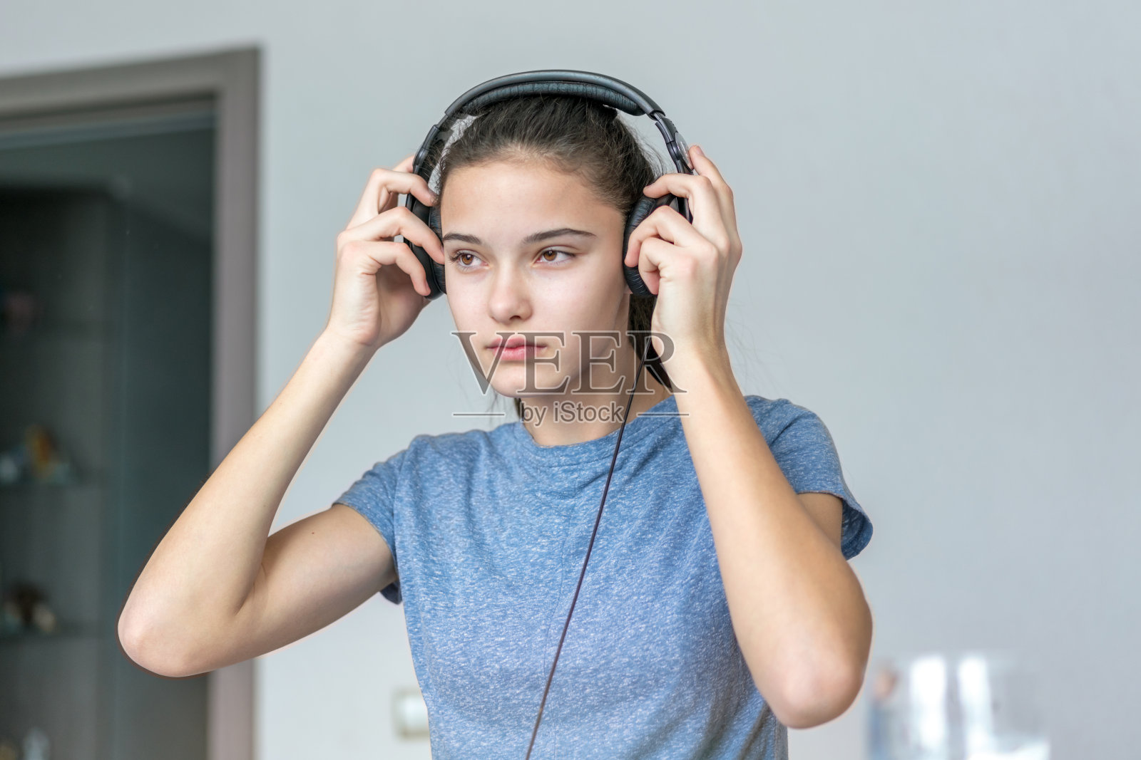 一个女孩在房间里戴着耳机照片摄影图片