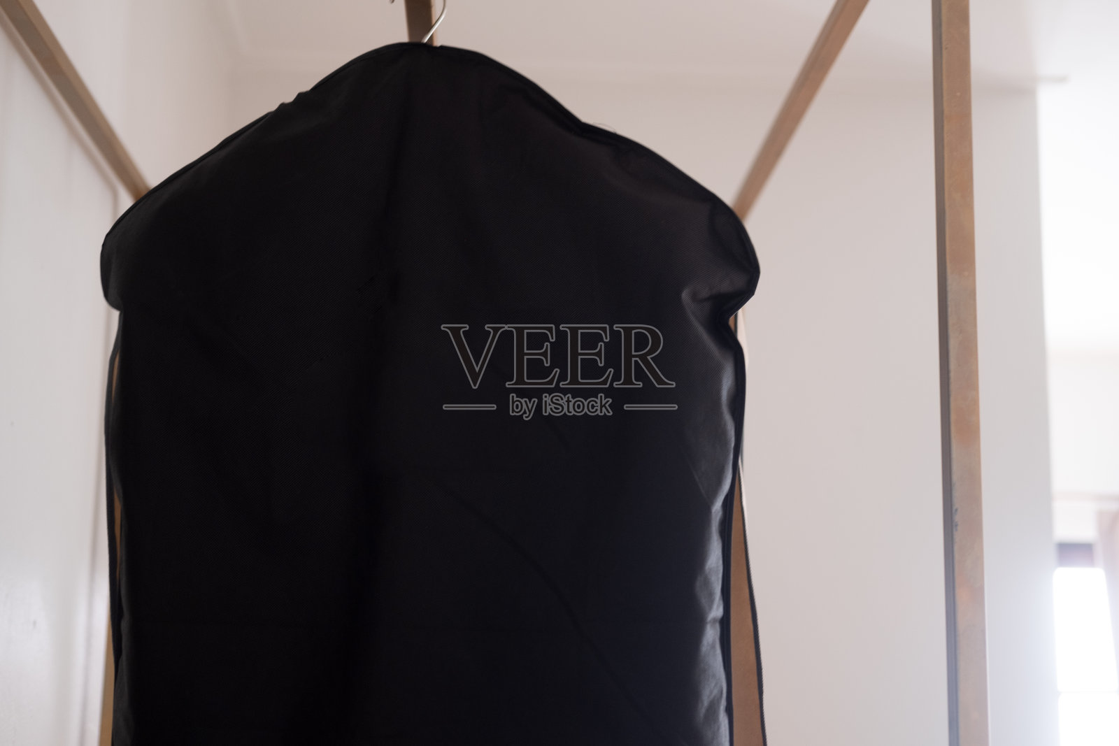 黑色西服套挂在晾干净衣服的架子上。近距离照片摄影图片