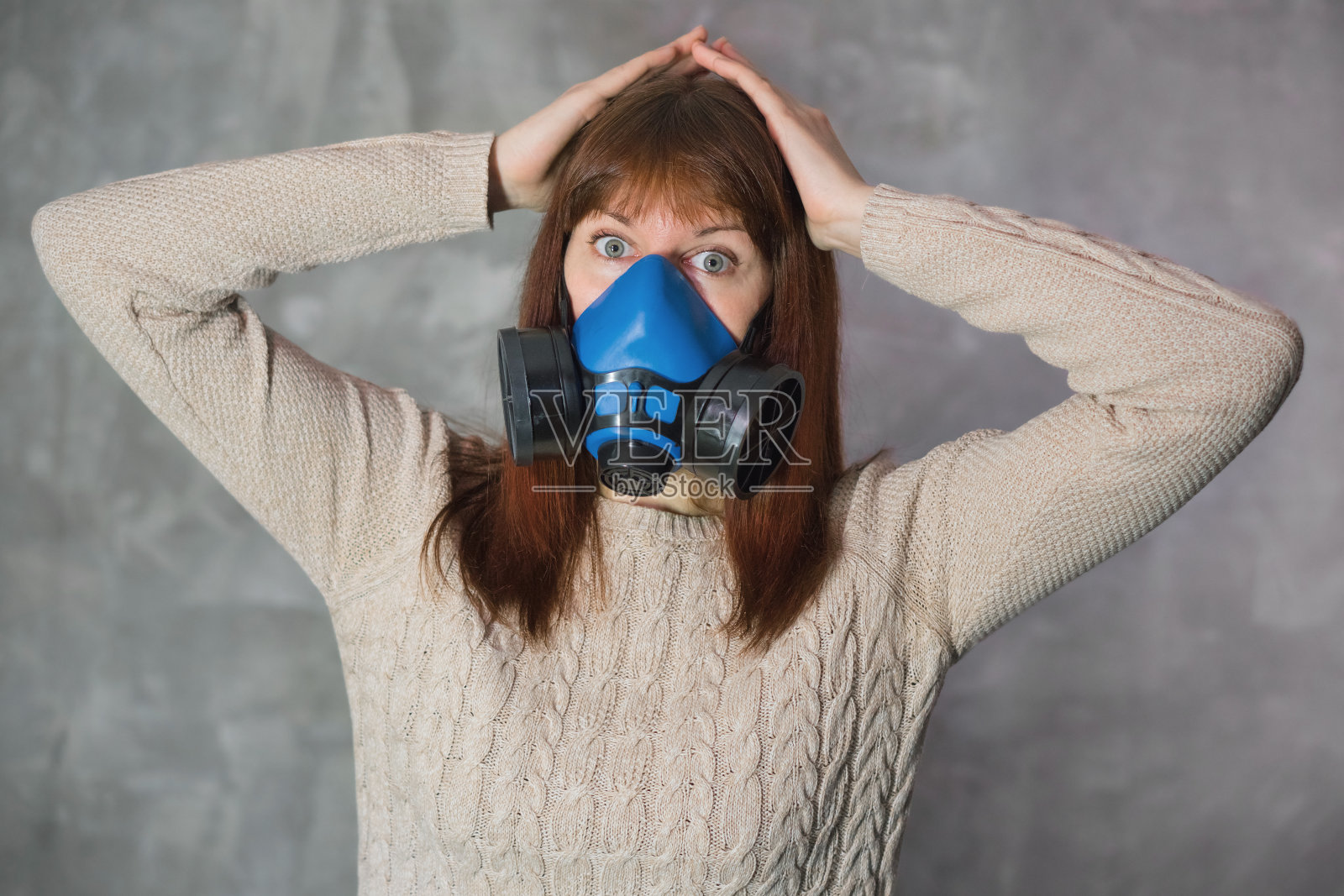 美丽的年轻女子在呼吸器站在灰色的背景。照片摄影图片