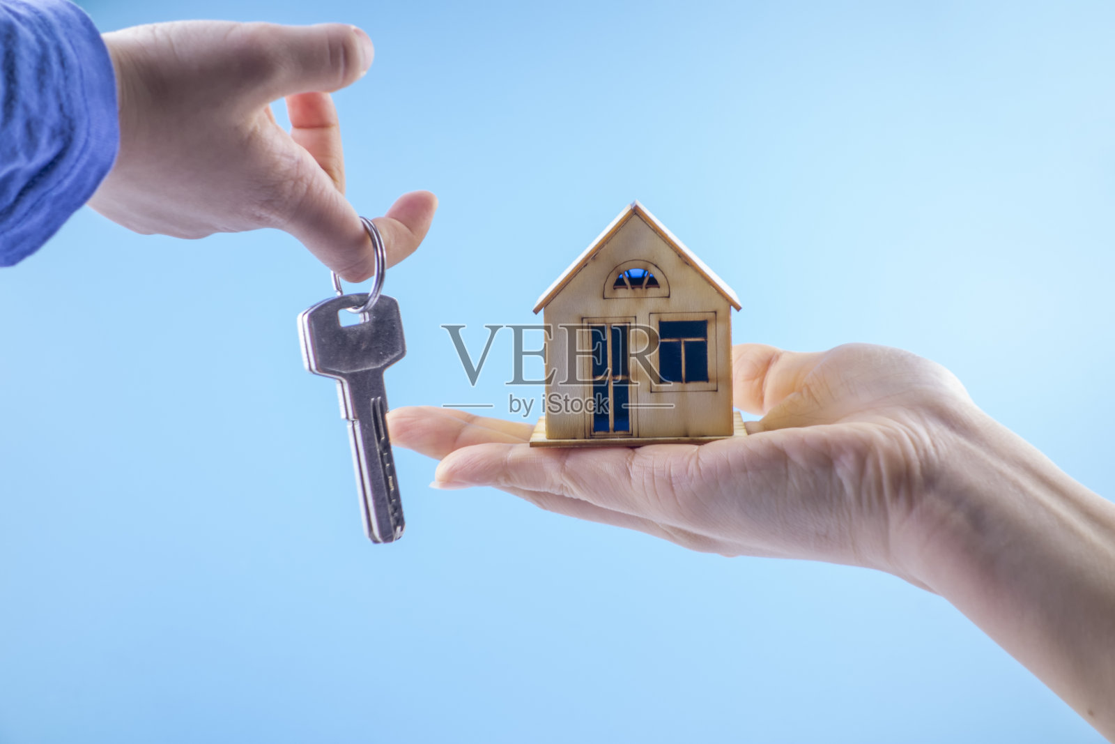 手里拿着钥匙和小房子照片摄影图片