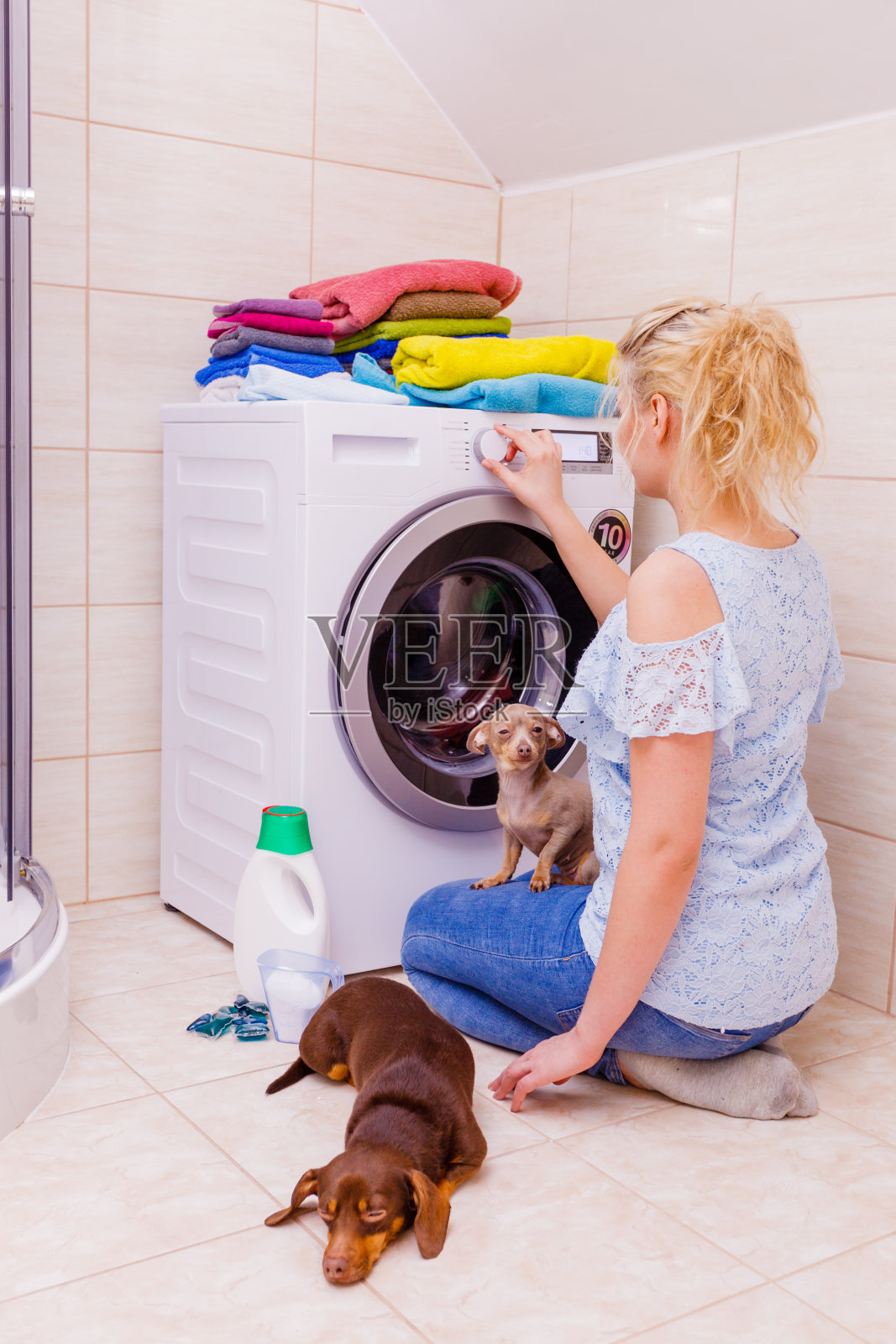 女人启动洗衣机。照片摄影图片