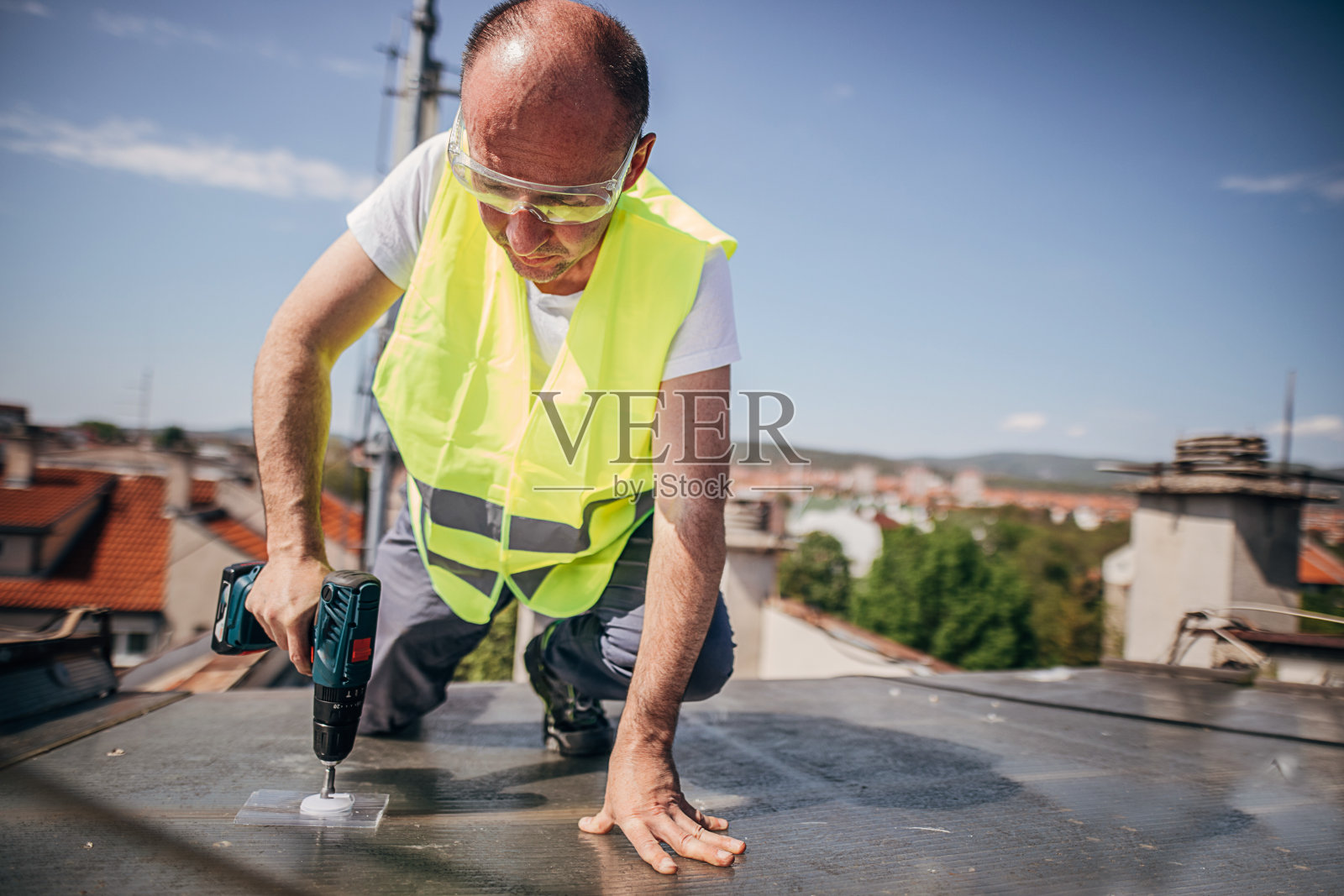 工人用电动螺丝刀修理屋顶照片摄影图片