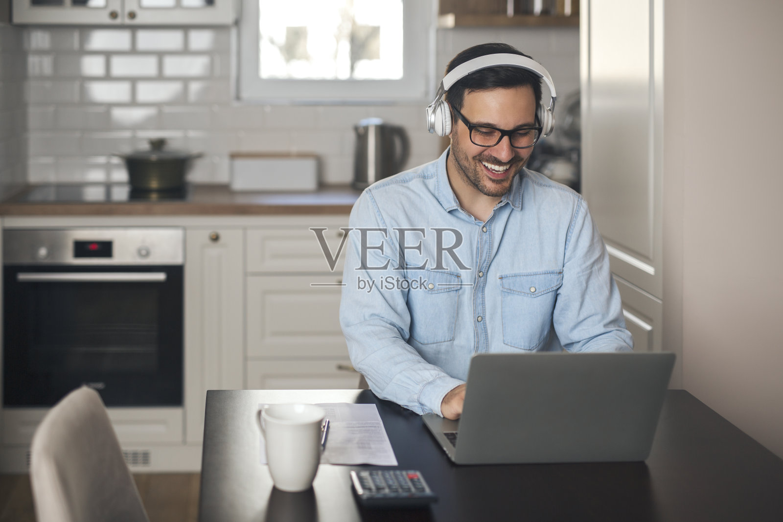 一个商人在笔记本电脑上听音乐的肖像。照片摄影图片