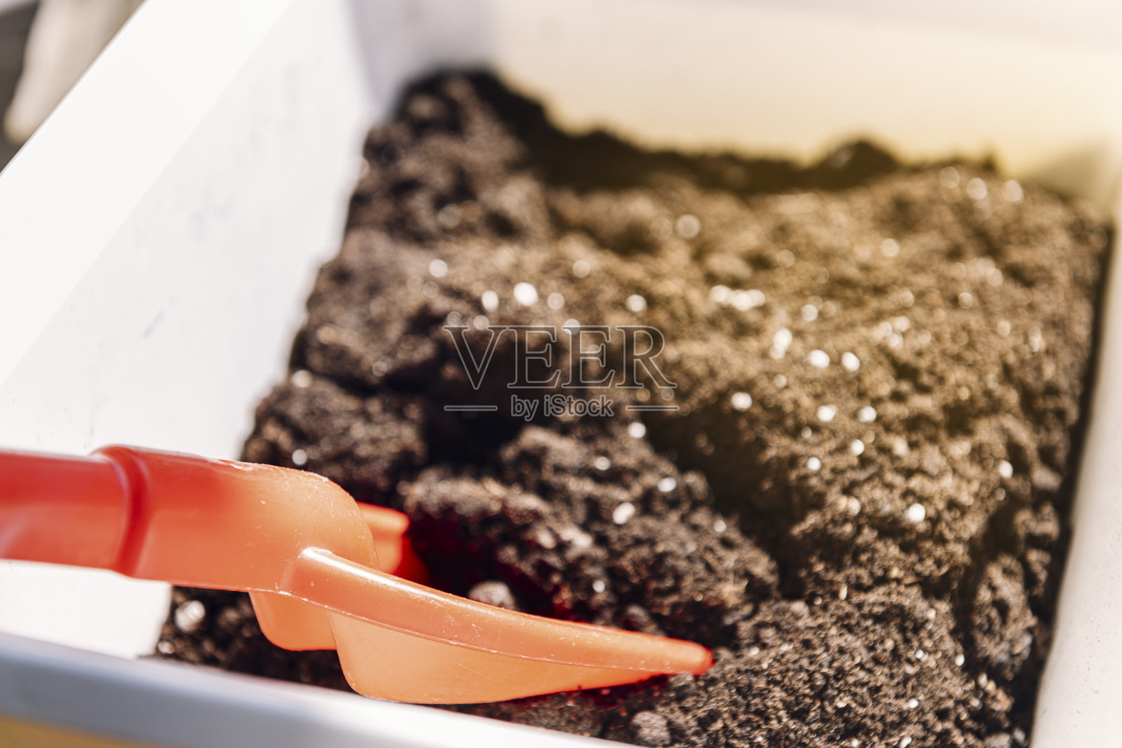 盒子里有园艺用的沙子和一把红色的铲子照片摄影图片