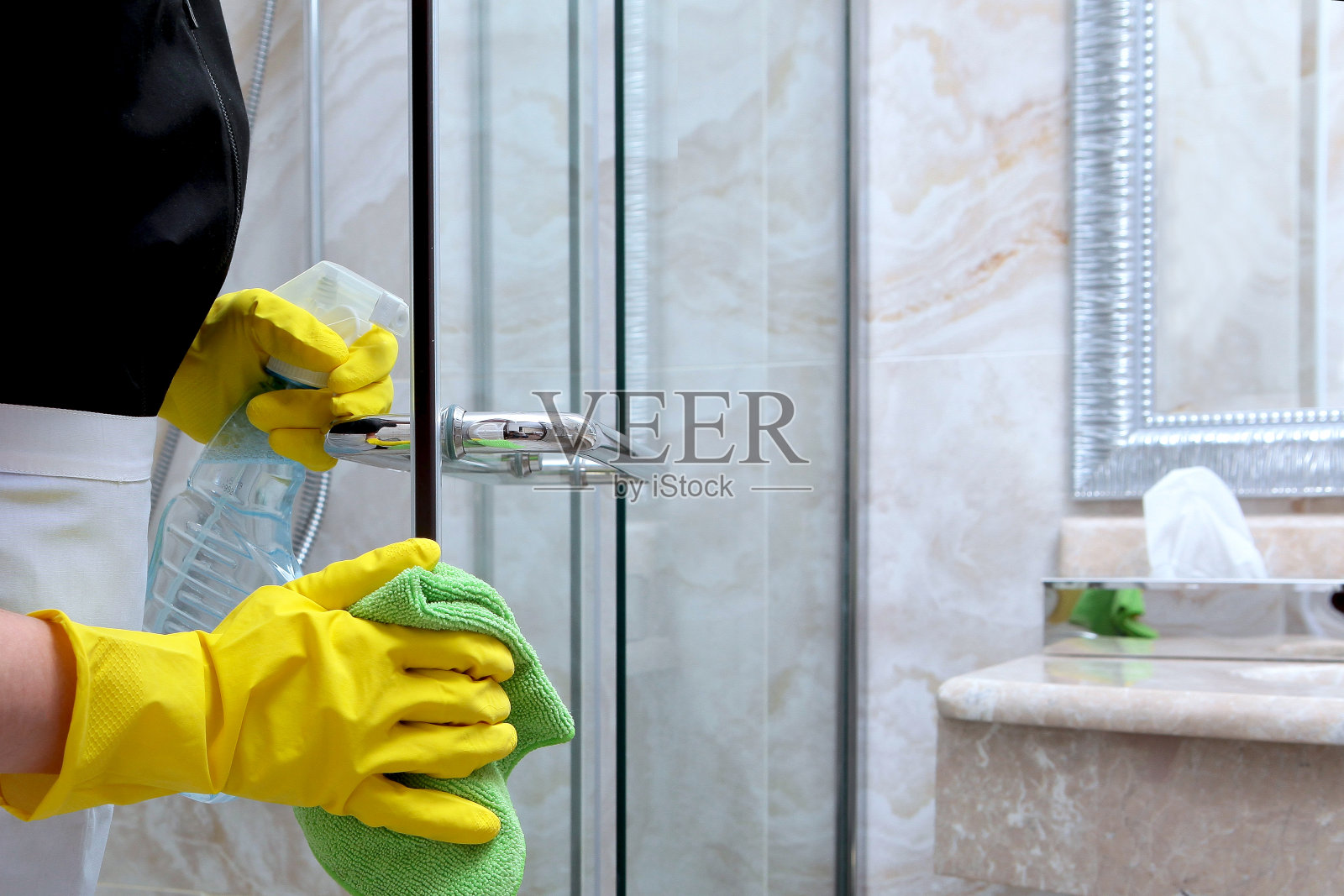 淋浴间的门是用餐巾洗的。在酒店或家里打扫卫生。认不出来照片。清洁和卫生的概念。照片摄影图片