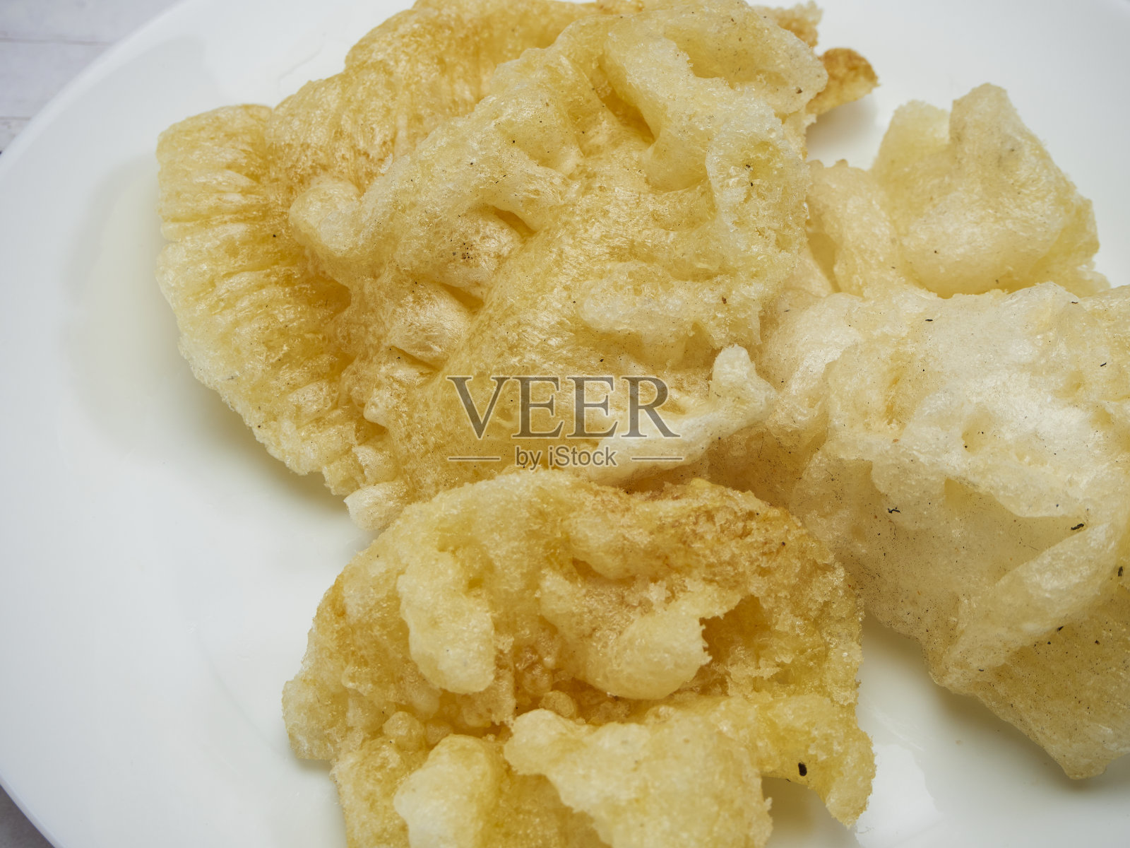 木桌上白色盘子里的鱼胃照片摄影图片