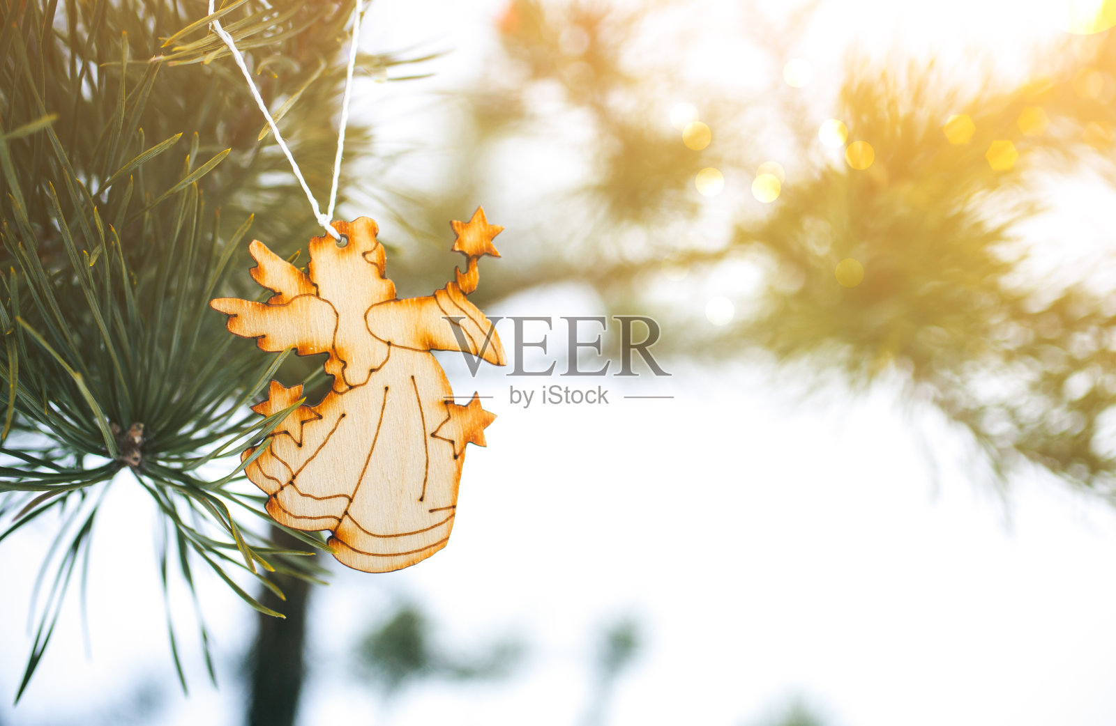 手工制作的天使挂在圣诞树上。冰冻森林中的自然照片。节日快乐装饰明信片。下雪的天气。照片摄影图片