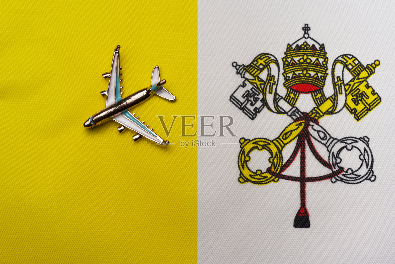 飞机飞越梵蒂冈城旗旅游概念。旗帜上的玩具飞机。照片摄影图片