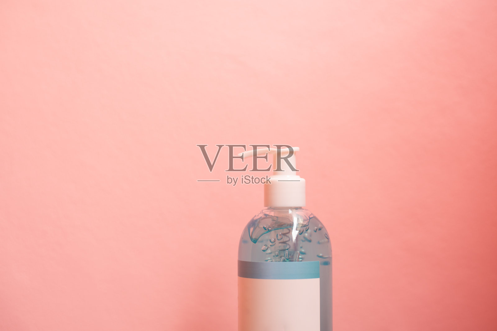 近距离的蓝色酒精凝胶在粉红色的粉彩背景。照片摄影图片