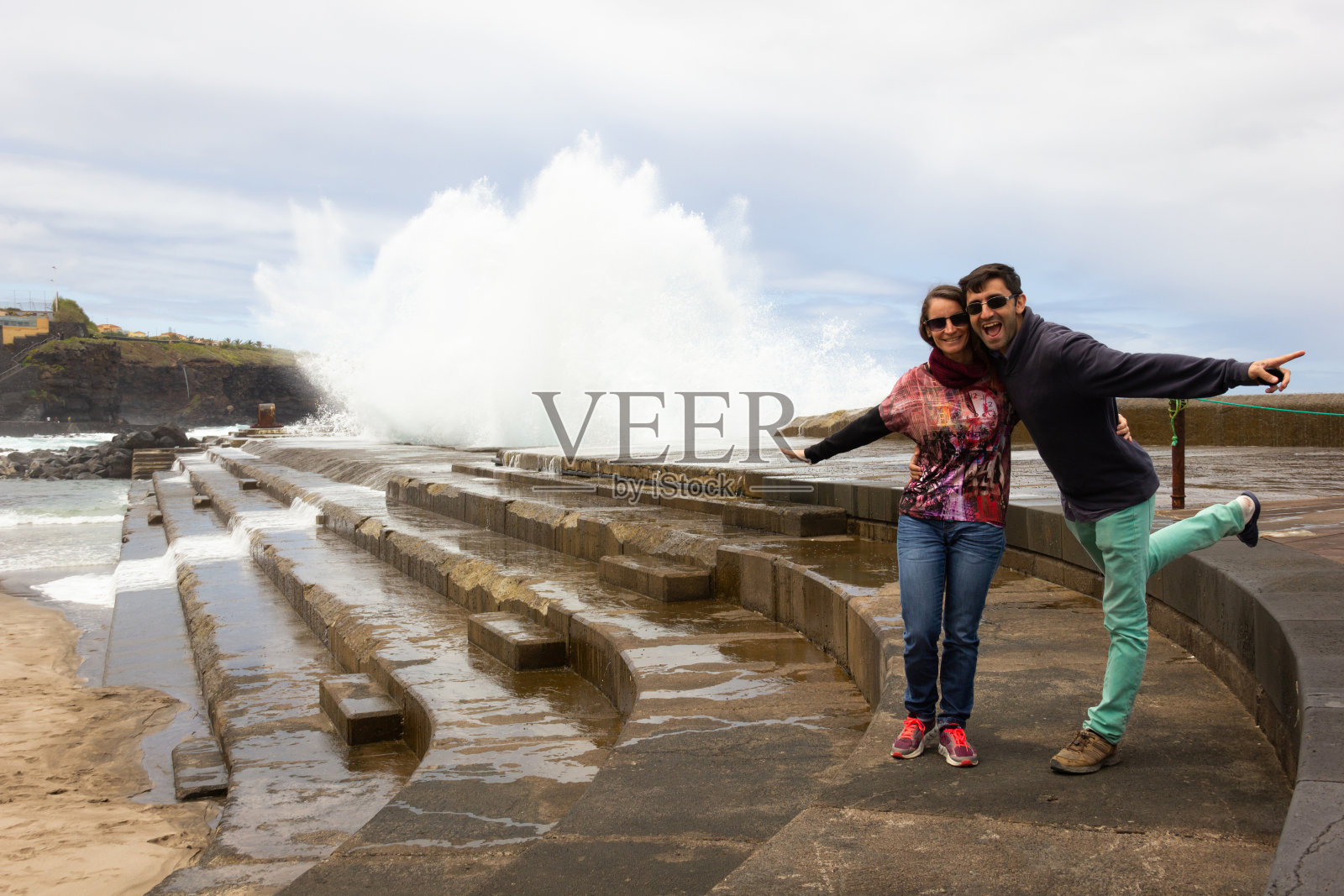 一对无畏的夫妇站在西班牙特内里费岛的巴贾马尔防波堤前照片摄影图片