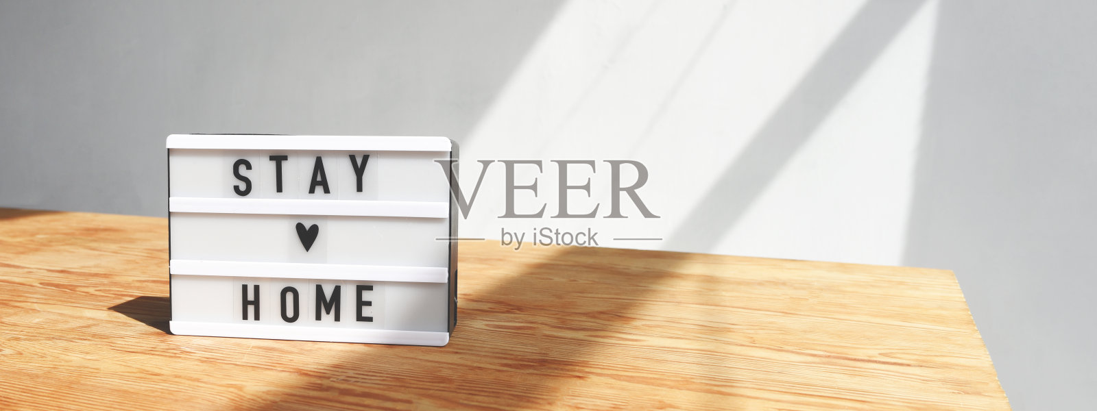 横幅上有灯箱的桌子上有铭文留在家里。照片摄影图片