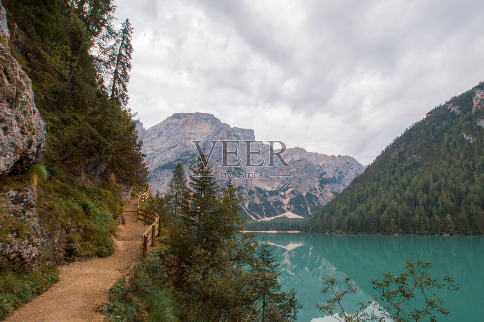 在多云的天空下，泥土路沿着布雷斯湖延伸照片摄影图片