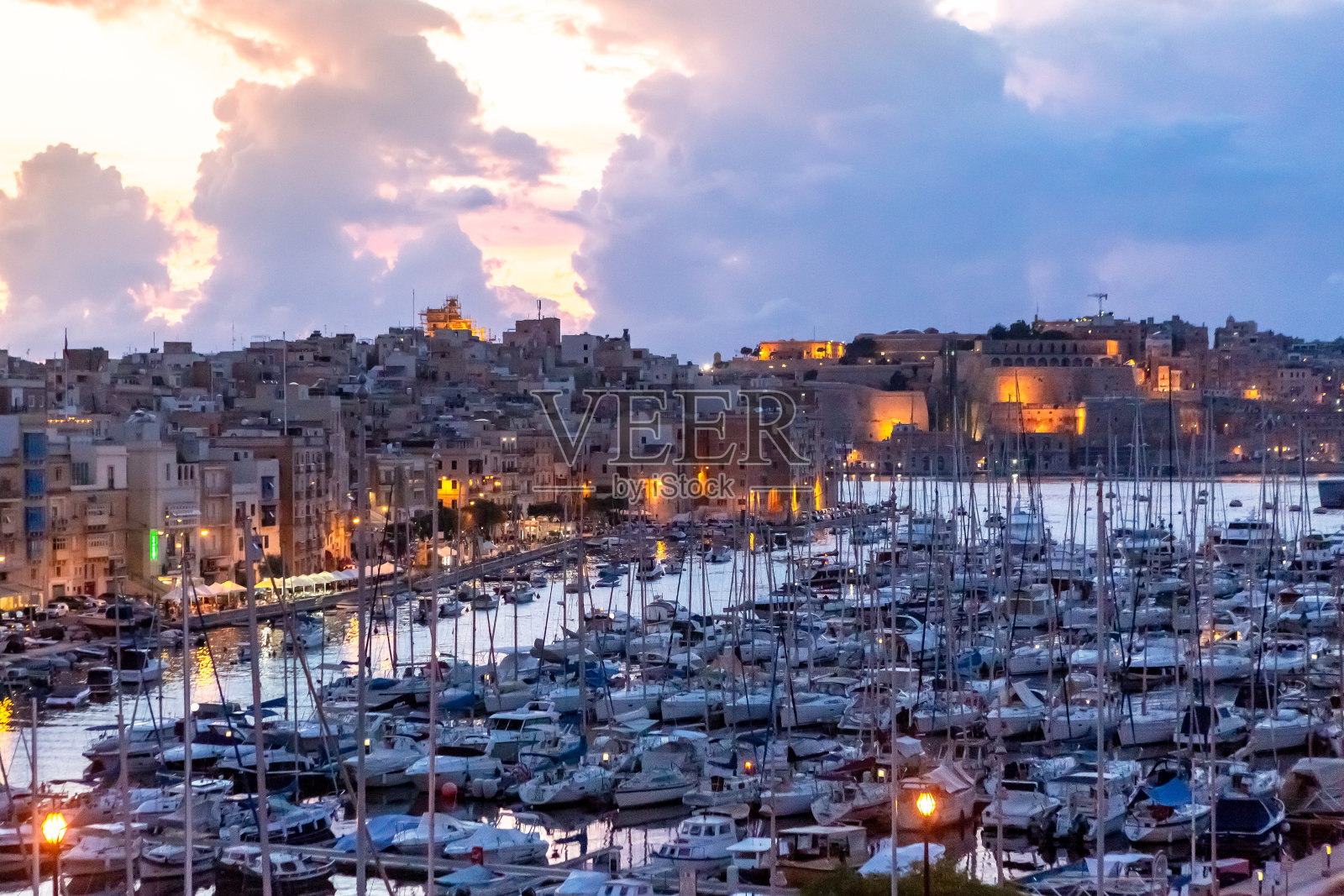 马耳他，日落时分马耳他岛瓦莱塔港的船只。照片摄影图片