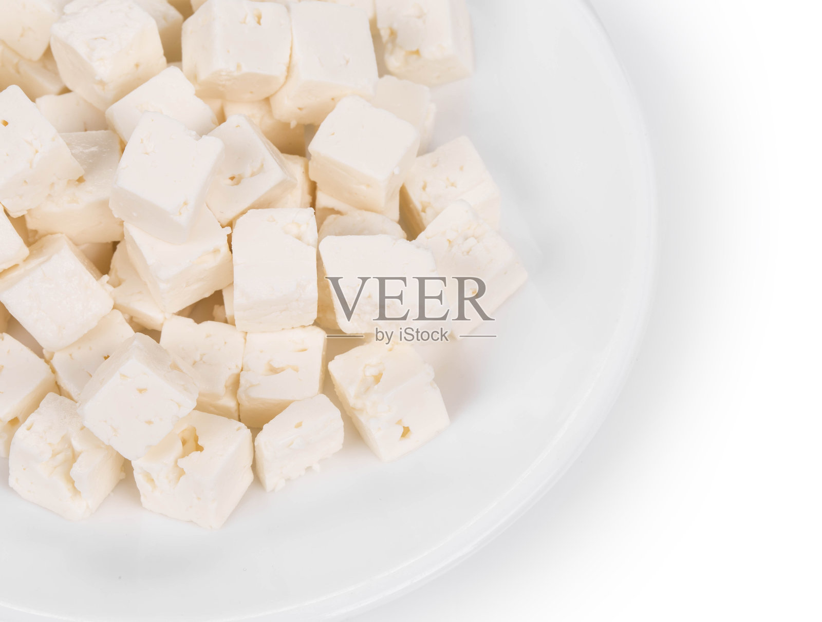 一块豆腐奶酪放在白色的盘子里。照片摄影图片