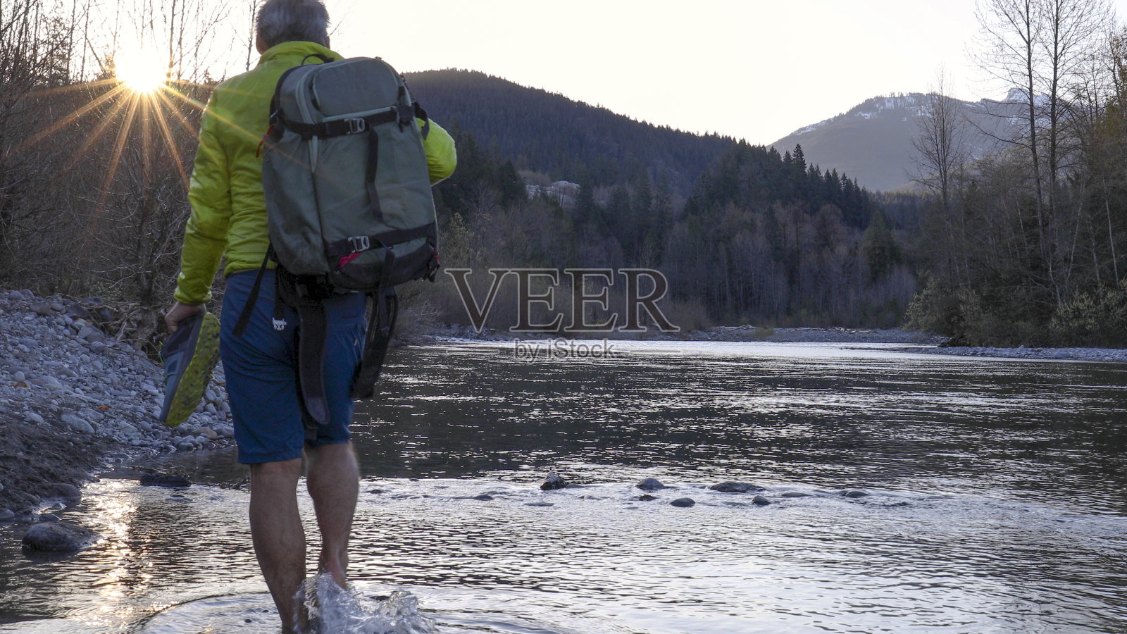 清晨，男子在河边休息照片摄影图片