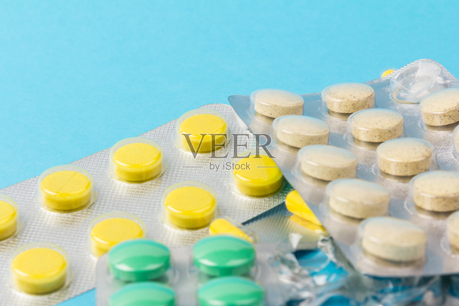 不同的药片，泡罩包装的药片，蓝色背景的药品照片摄影图片