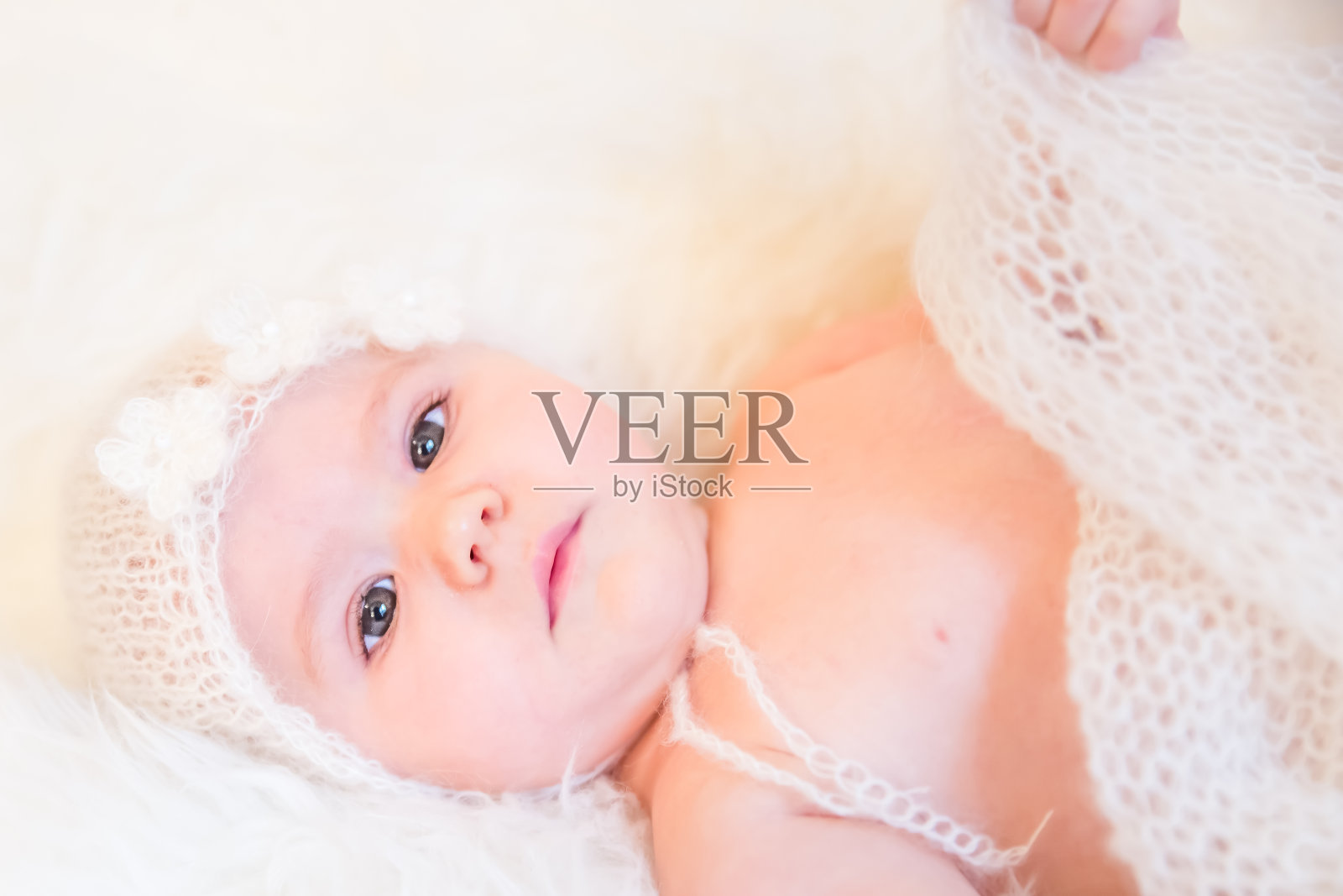 可爱的小女孩戴着柔软的毛线帽子和花照片摄影图片