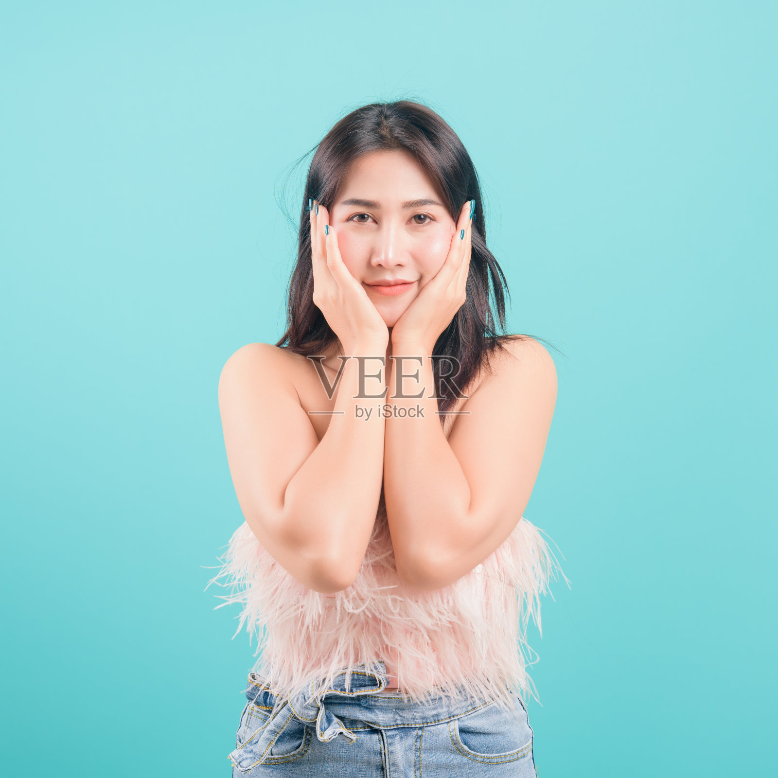 亚洲幸福的肖像美丽的年轻女子站在微笑惊讶兴奋她的手捂着她的脸，看着蓝色背景与旗帜的文本复制空间的相机照片摄影图片