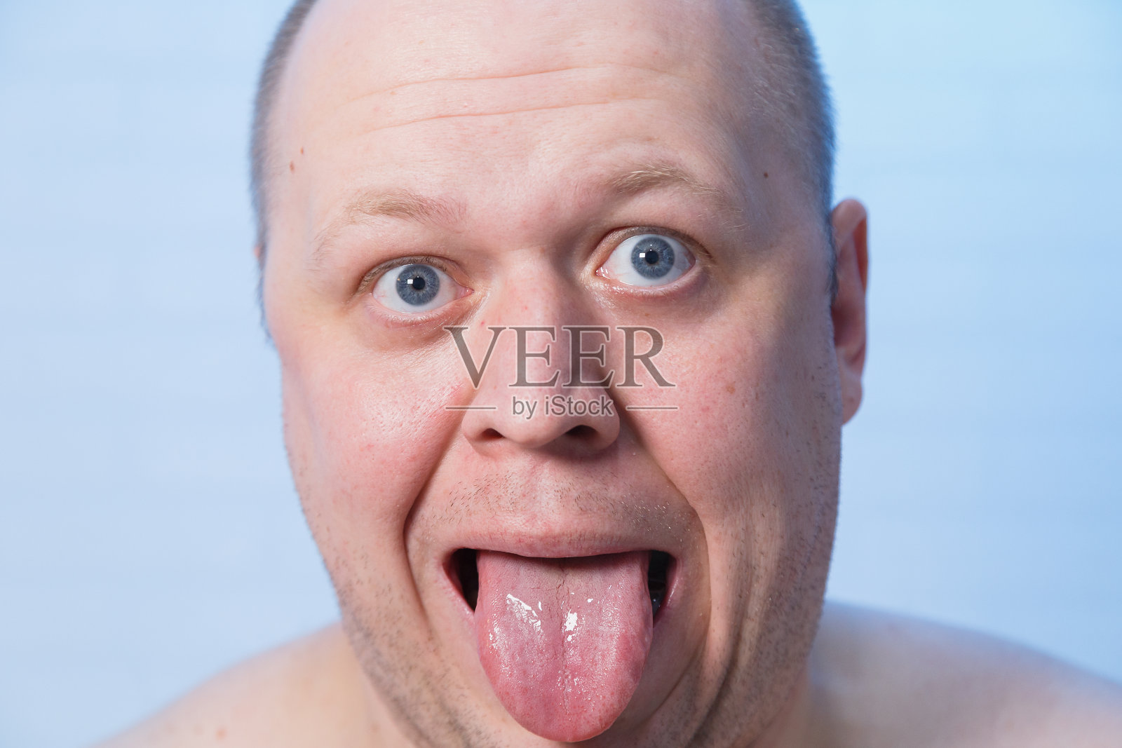 一个露出舌头的秃顶男人的肖像照片摄影图片