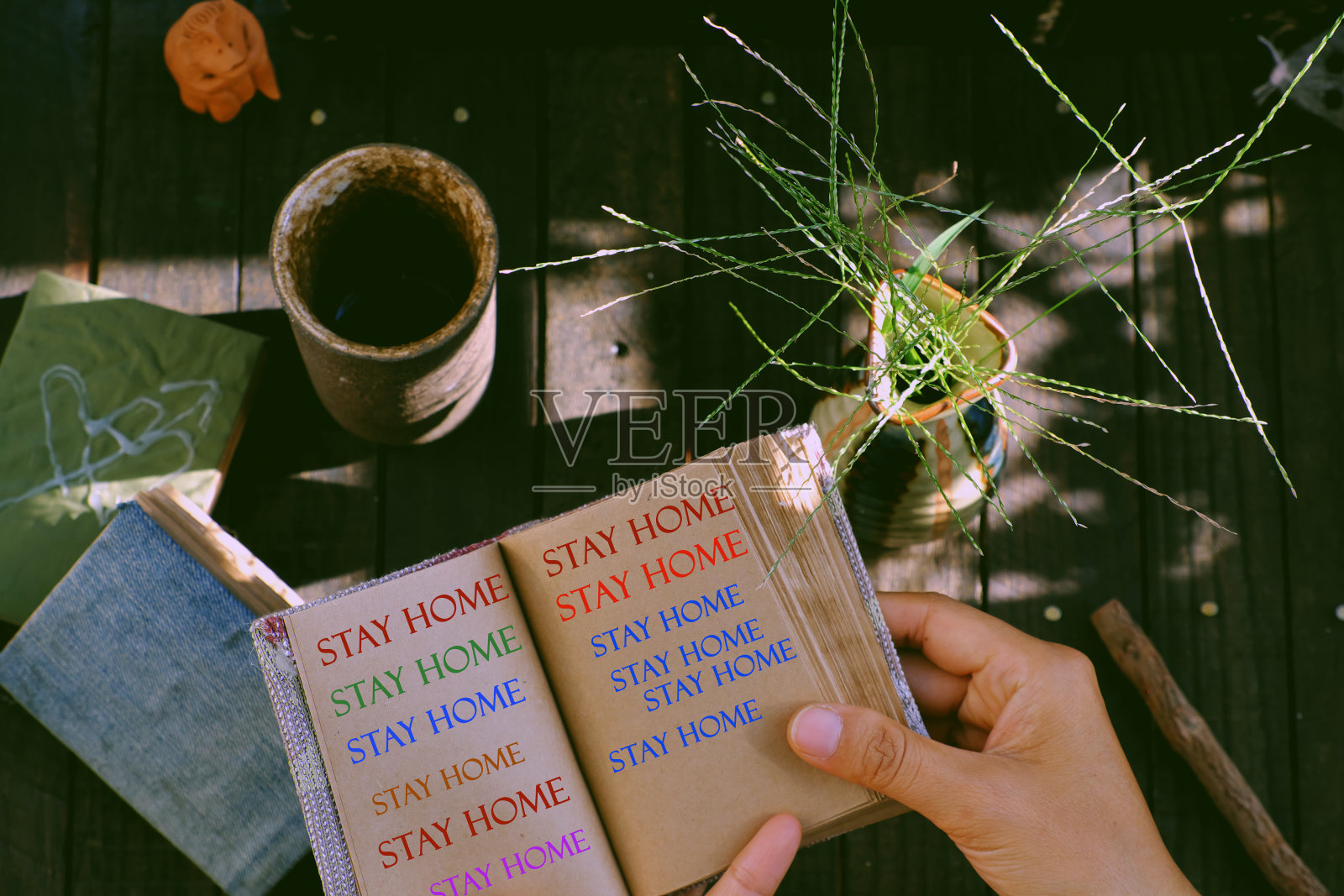 妇女手持一张印有居家信息的纸条，在疫情季节被冠状病毒感染，在社会隔离期间在家工作照片摄影图片