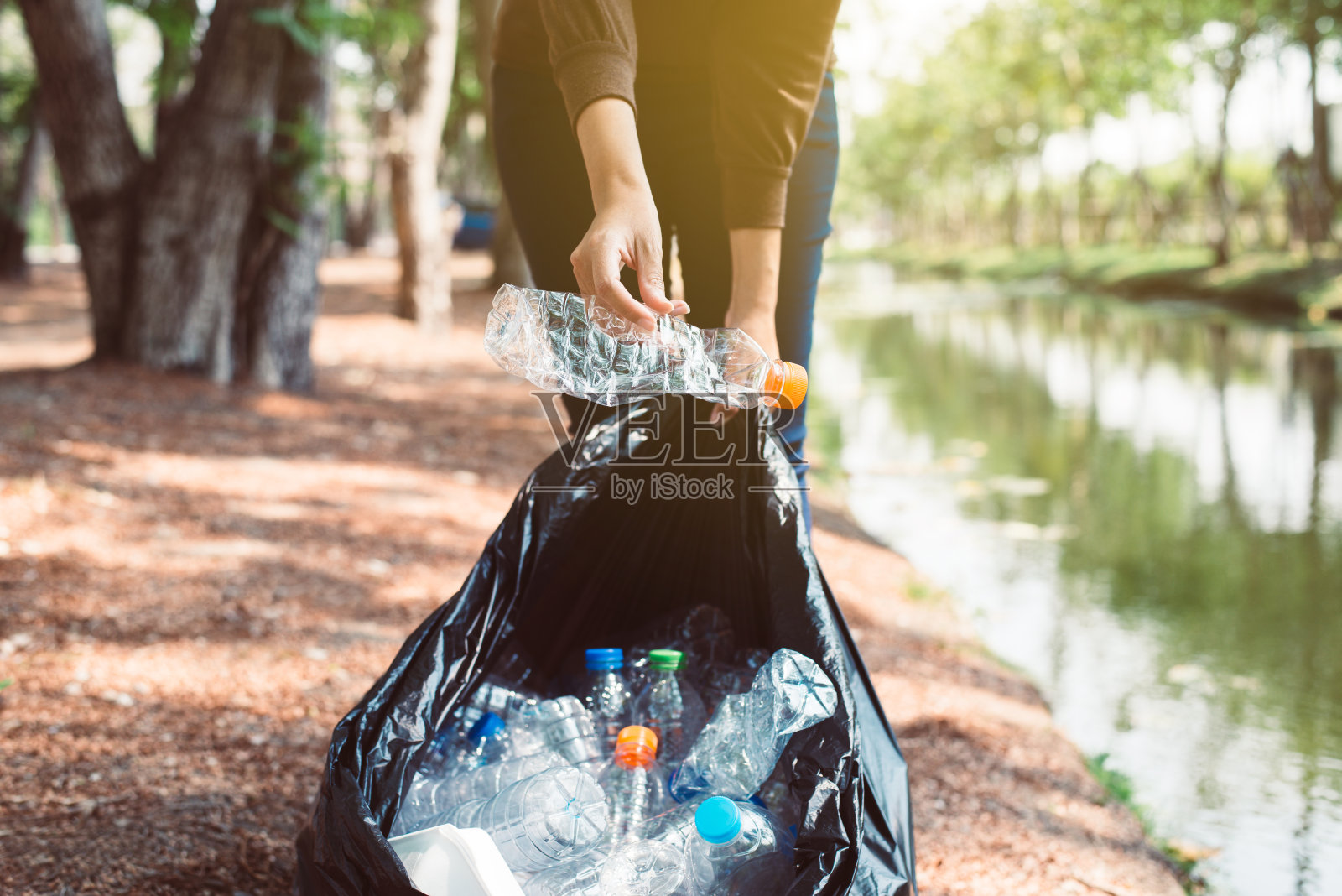 妇女志愿者在公园保存塑料垃圾，处理回收和废物管理理念照片摄影图片