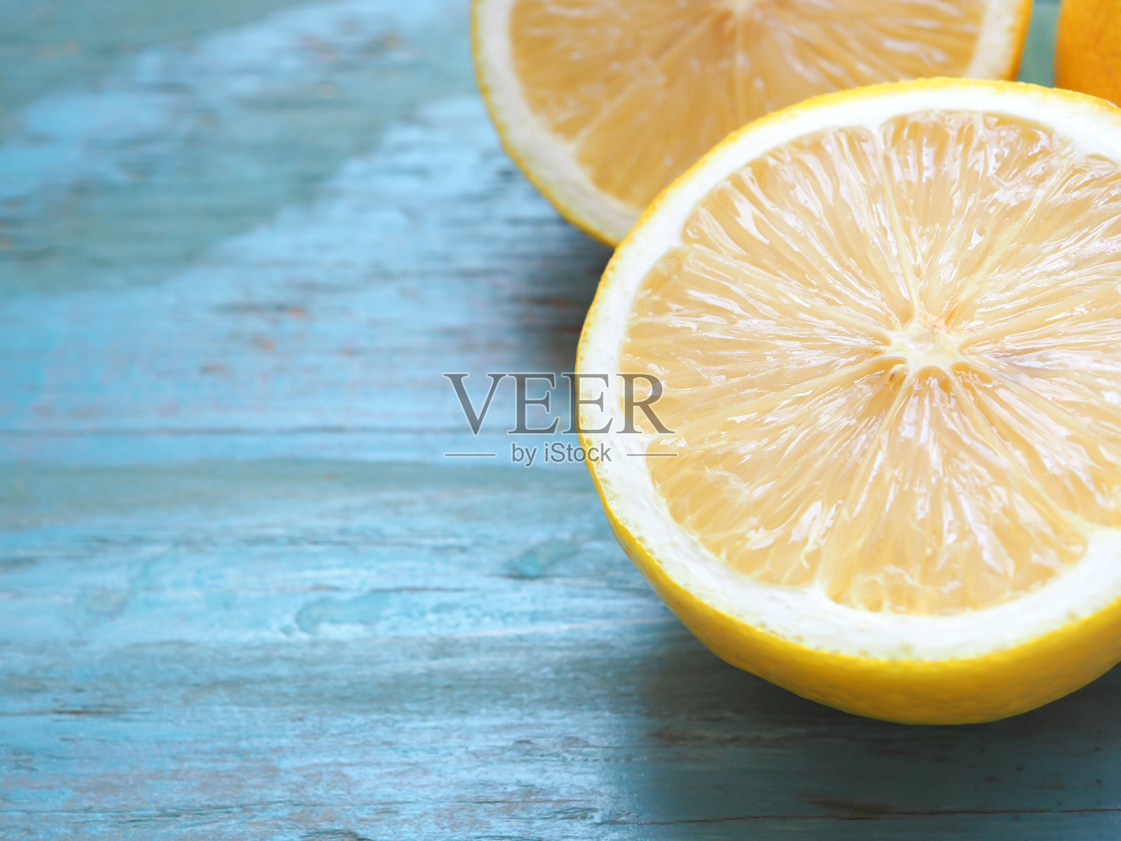 关闭一半柠檬在蓝色背景与复制空间。照片摄影图片