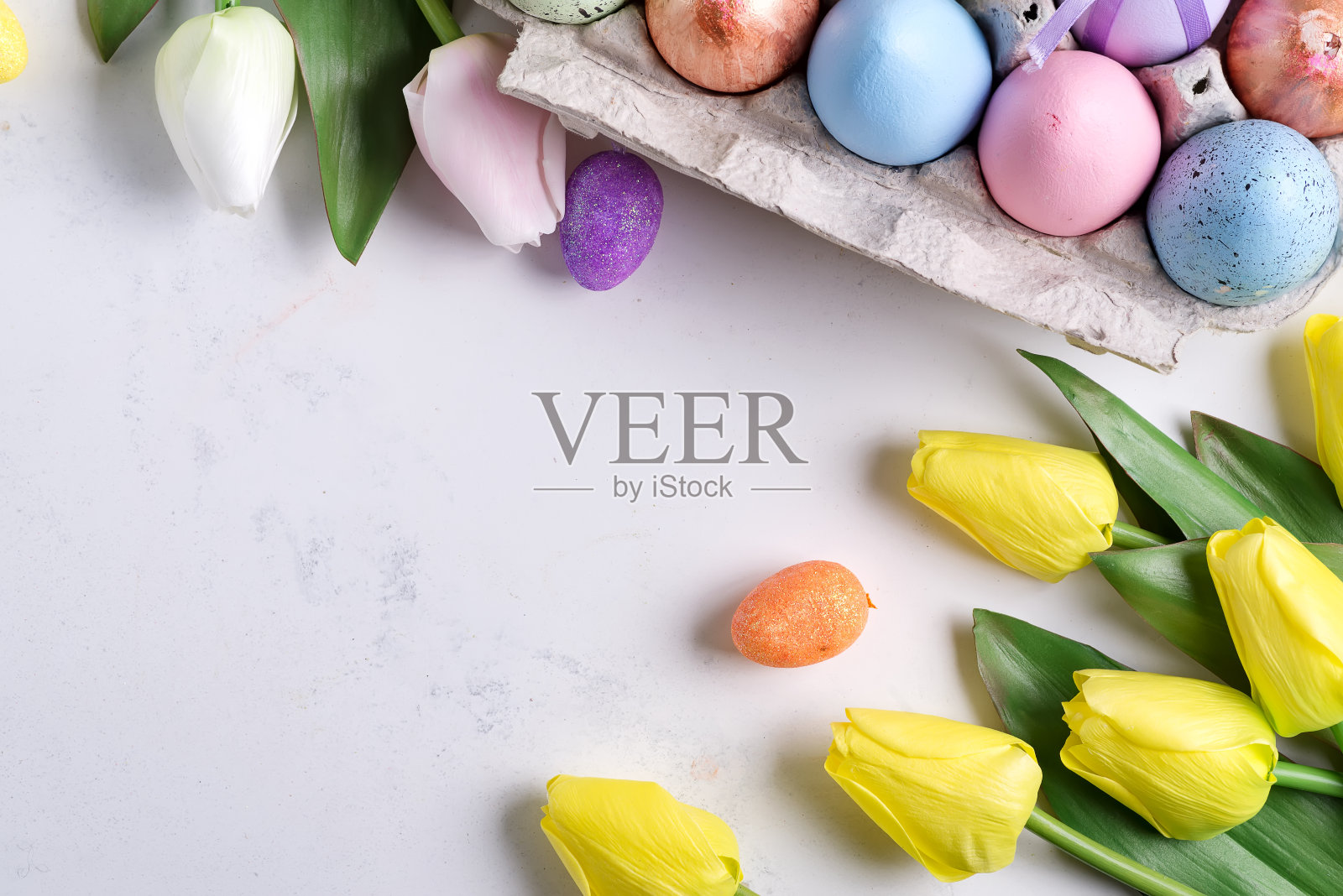 复活节彩蛋盒与黄色郁金香在石材大理石的背景。复活节背景或复活节概念。照片摄影图片